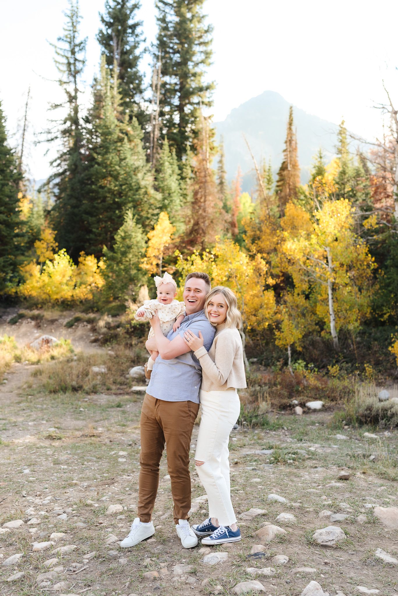A family enjoying a tender moment together in a mountain setting with golden aspens.