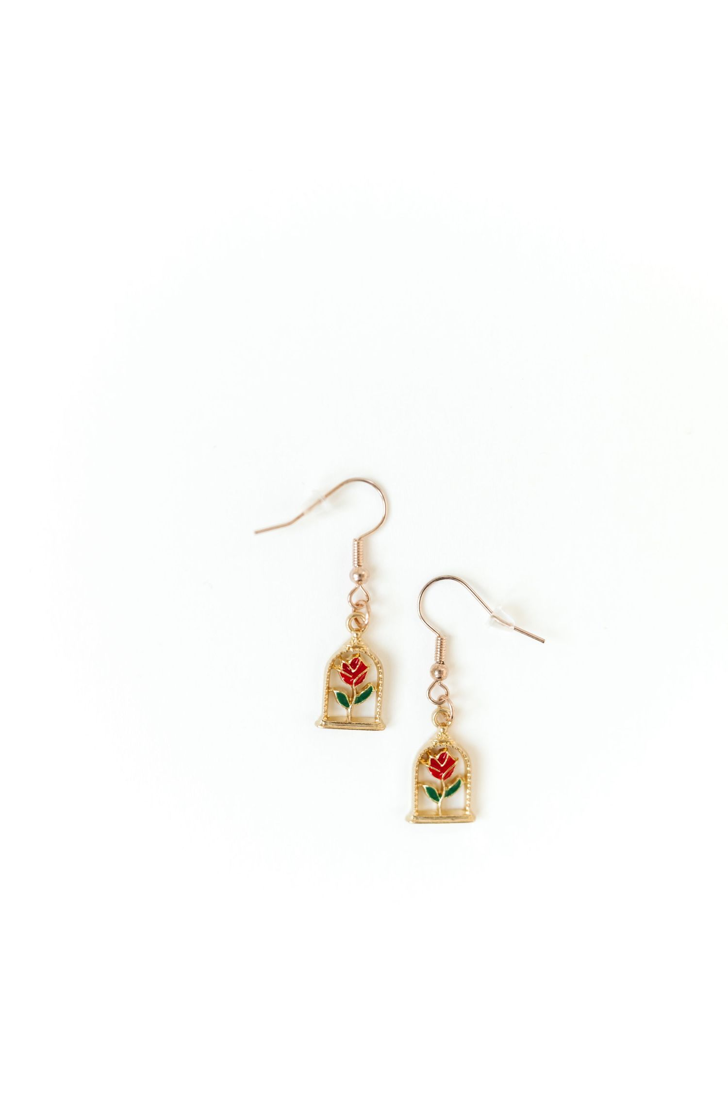 Delicate gold earrings with floral design displayed on white background.