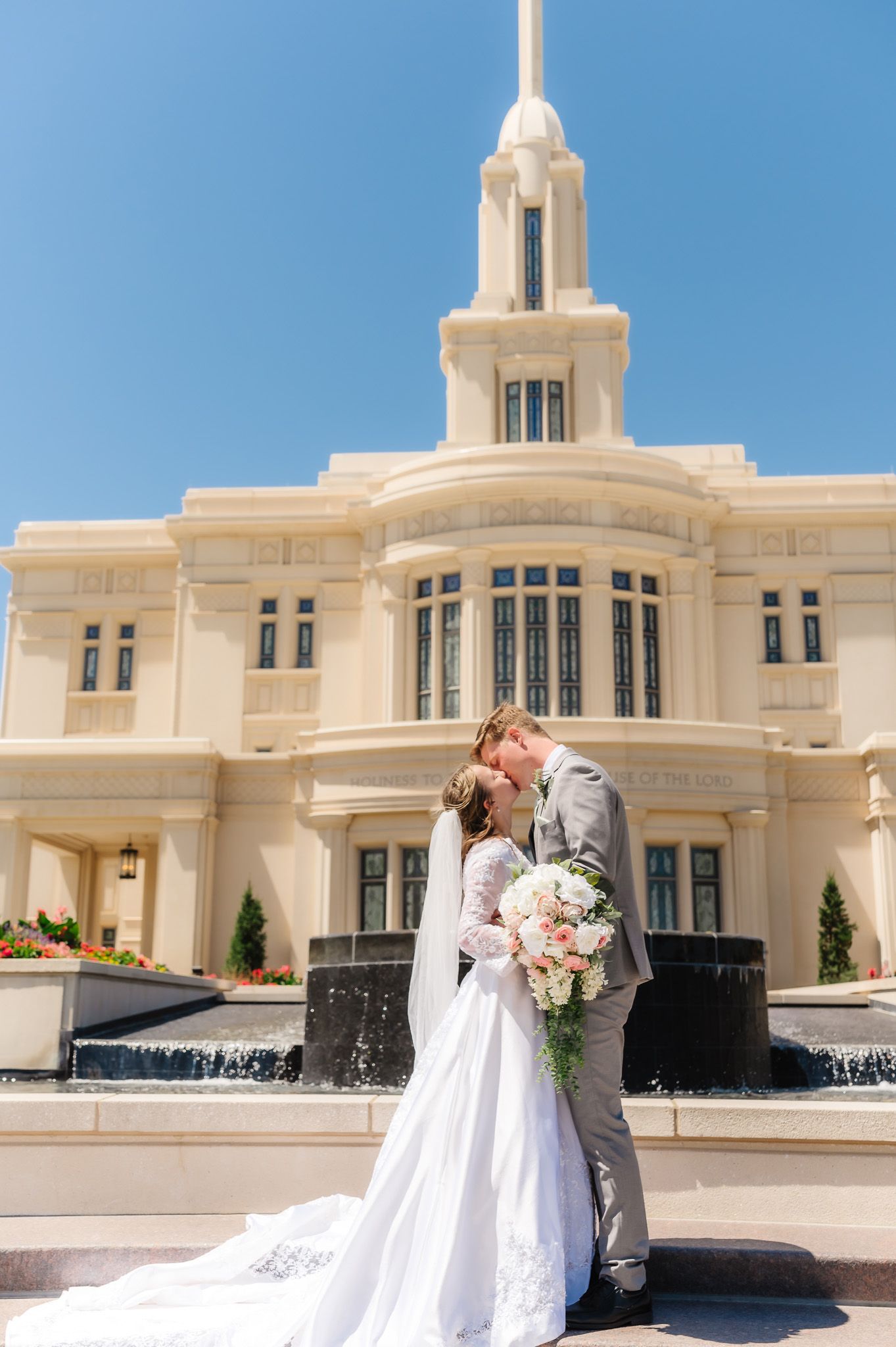 Bride and groom share romantic moments in front of a beautiful white temple building.