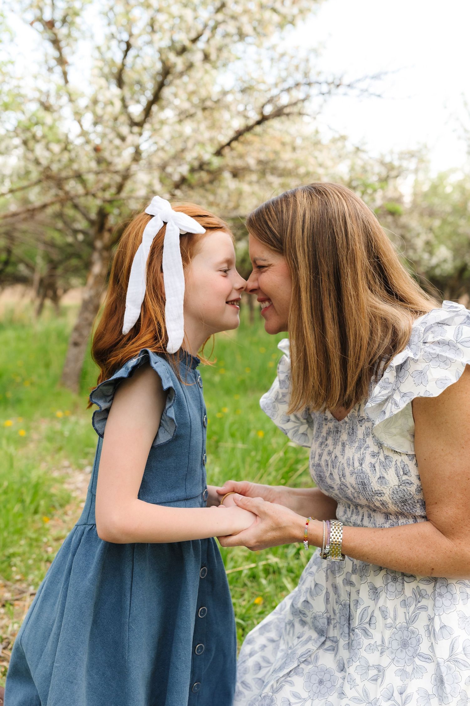 Two people sharing a tender moment among flowering trees in springtime.