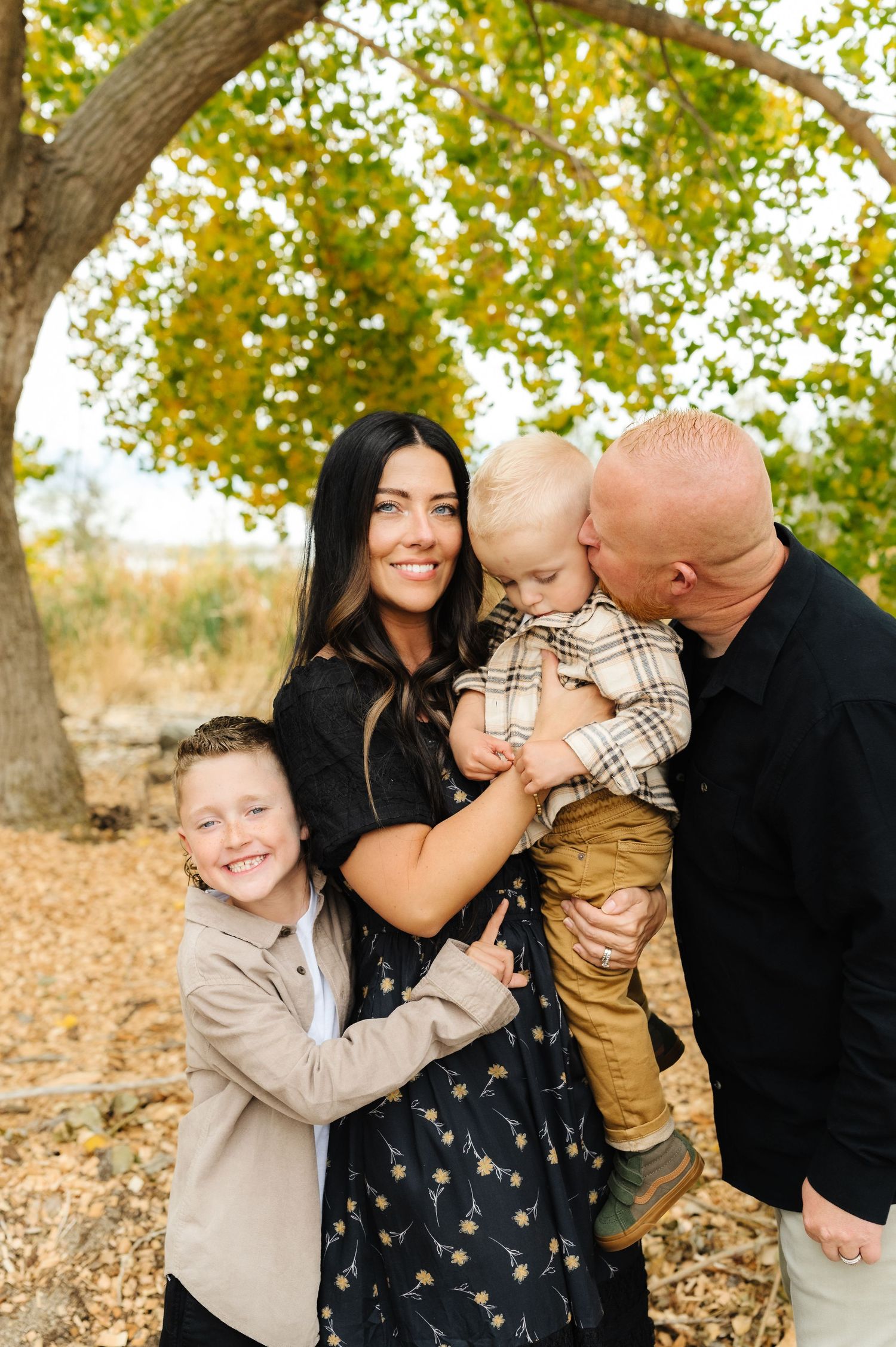 A playful family photo sequence under autumn trees with golden leaves.