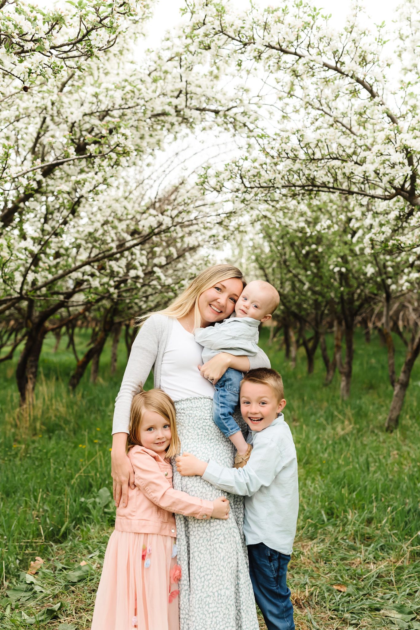 Family sharing joyful moment together under blooming spring trees.