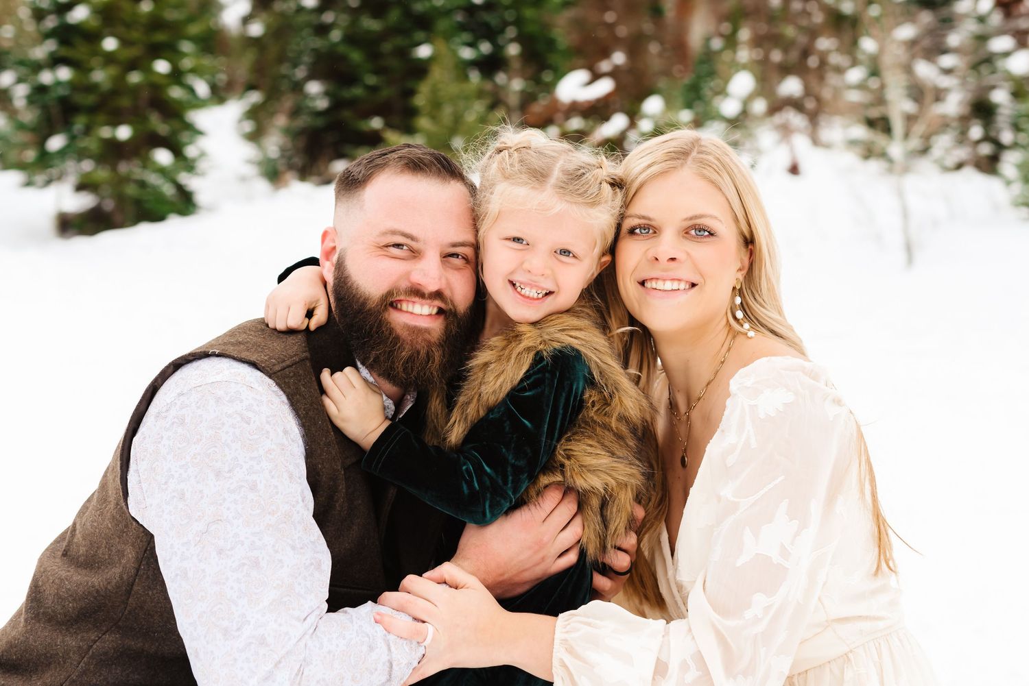 Candid winter engagement photography session showing tender moments in a snow-covered mountain setting.