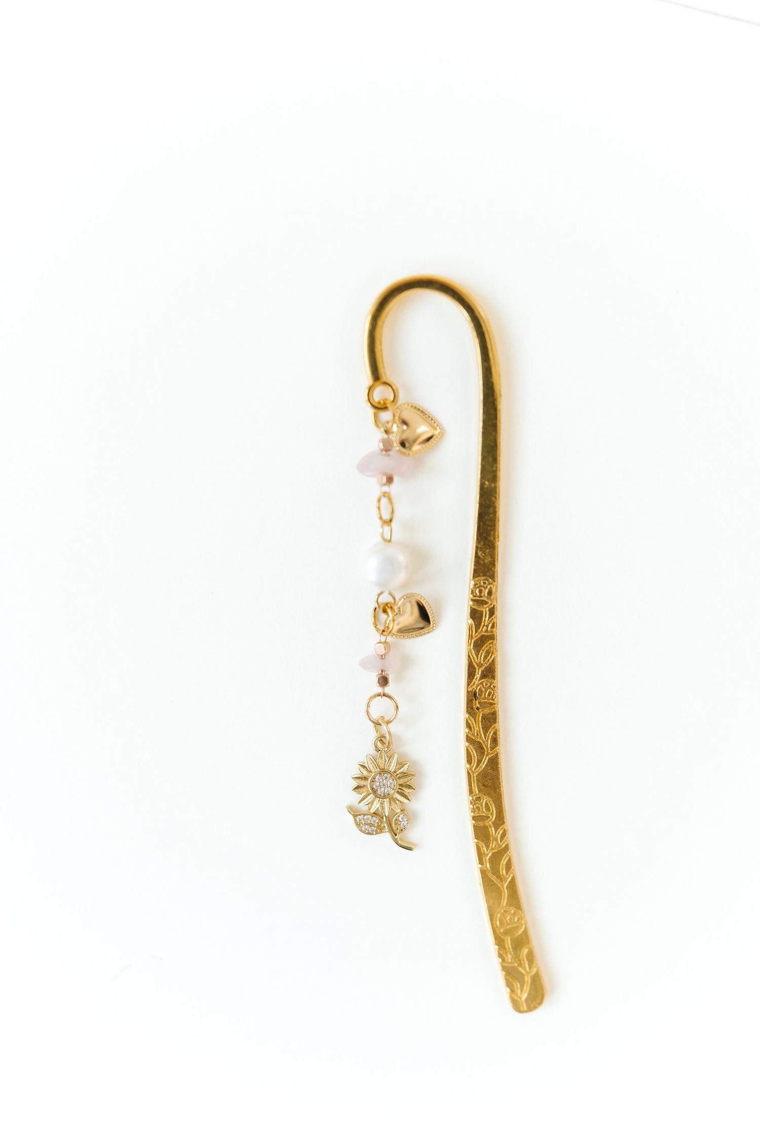 Gold-toned decorative bookmarks with dangling crystal charms displayed on white.