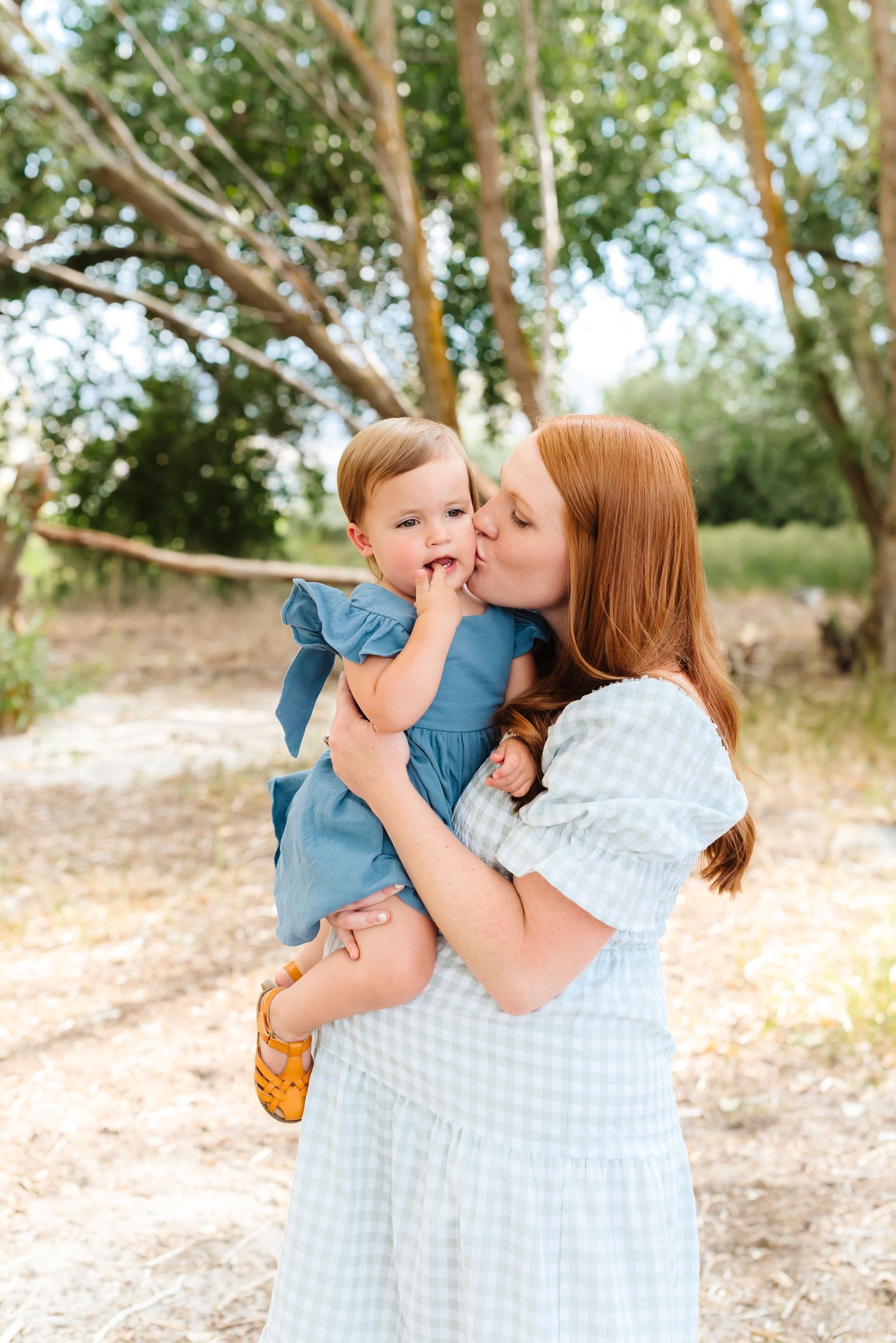 Playful family photography session showing joyful interactions in a natural outdoor setting.