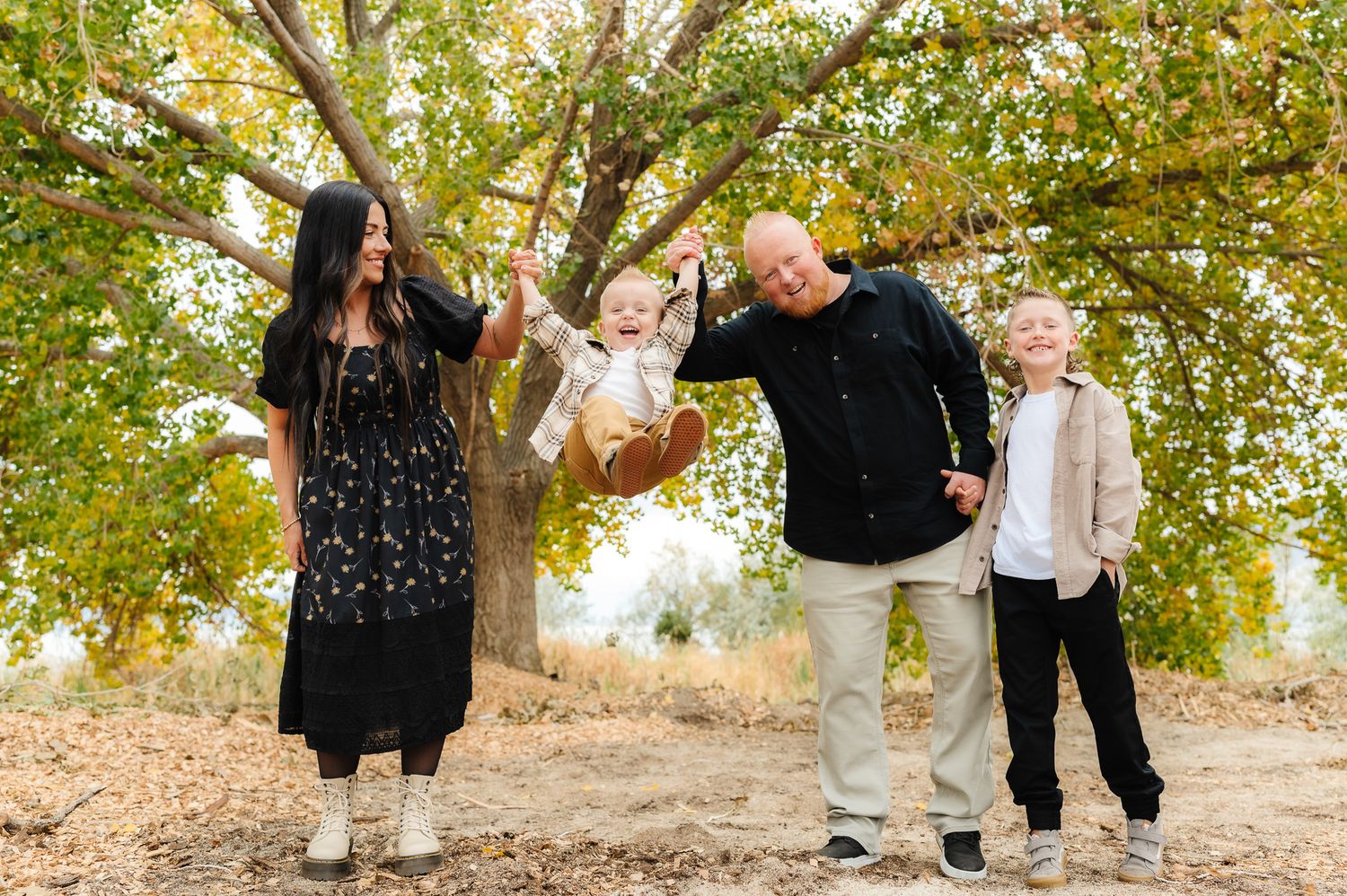 Family photoshoot with multiple candid moments under autumn trees.
