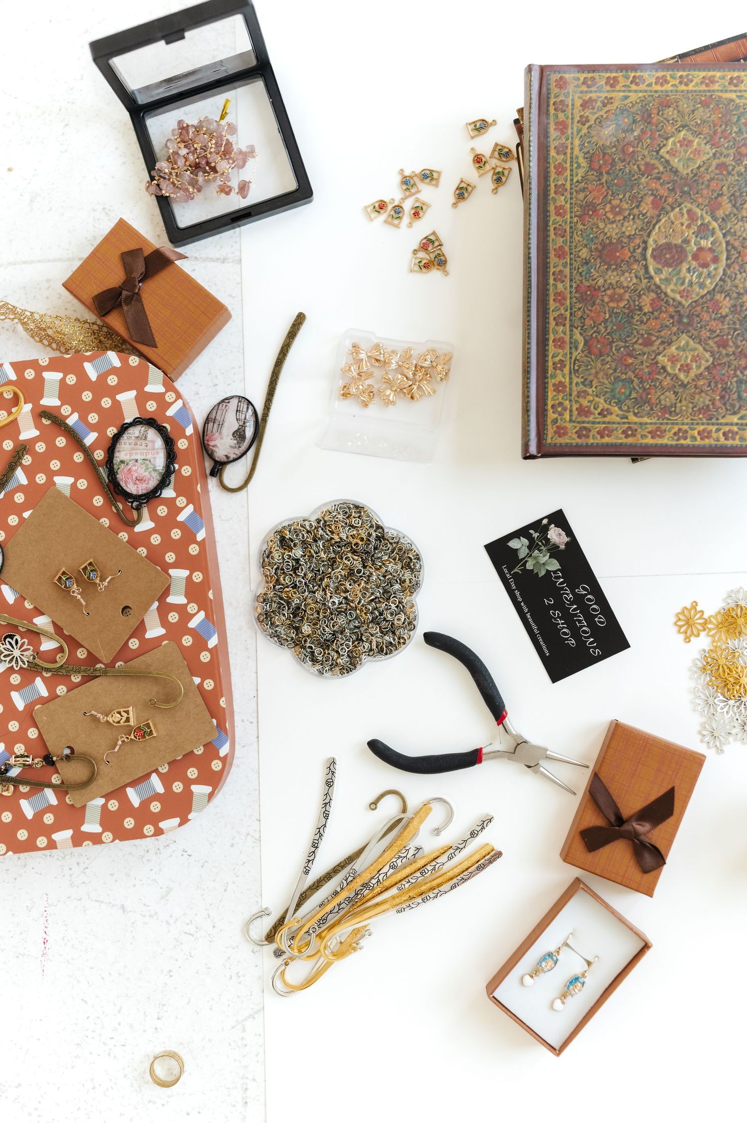 Flat lay of craft supplies including scissors, boxes, and decorative papers on white background.