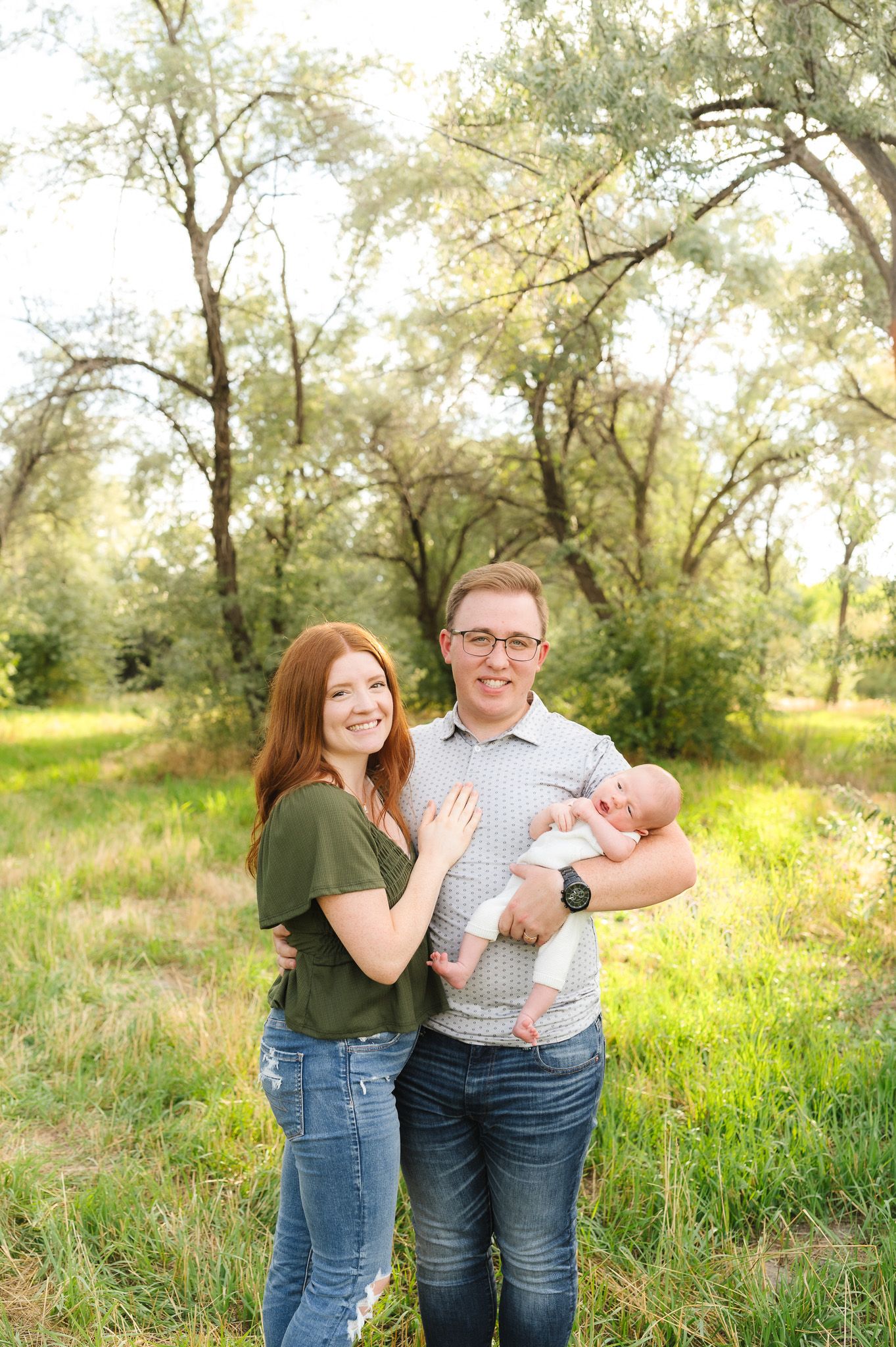 Casual outdoor portrait session in a natural setting with wildflowers and trees.