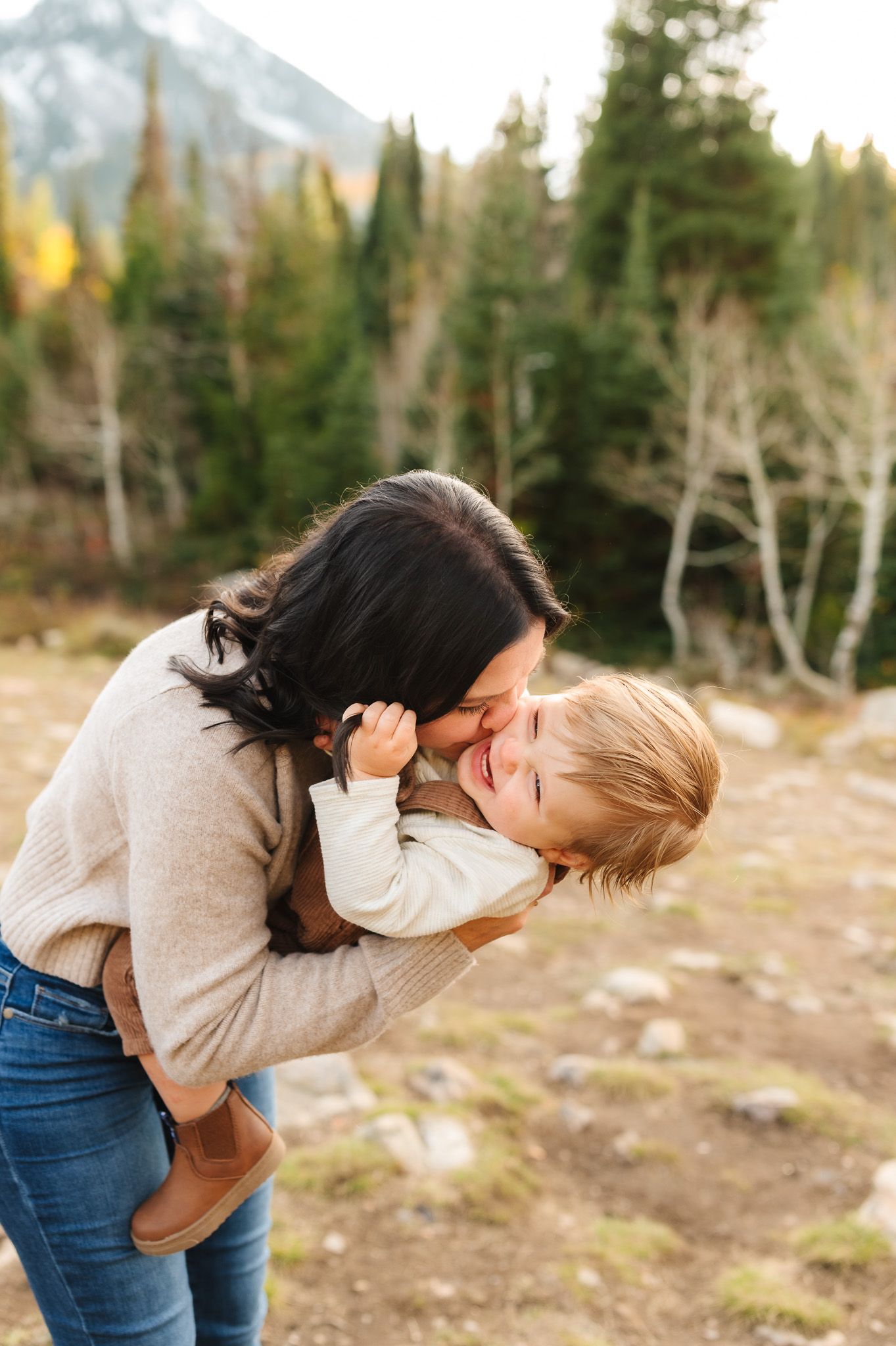 Tender family moment captured in mountain wilderness setting.