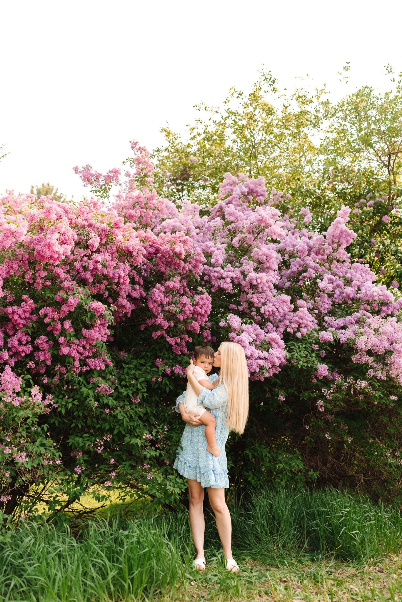 Two people embracing near blooming pink flowers on a sunny spring day.