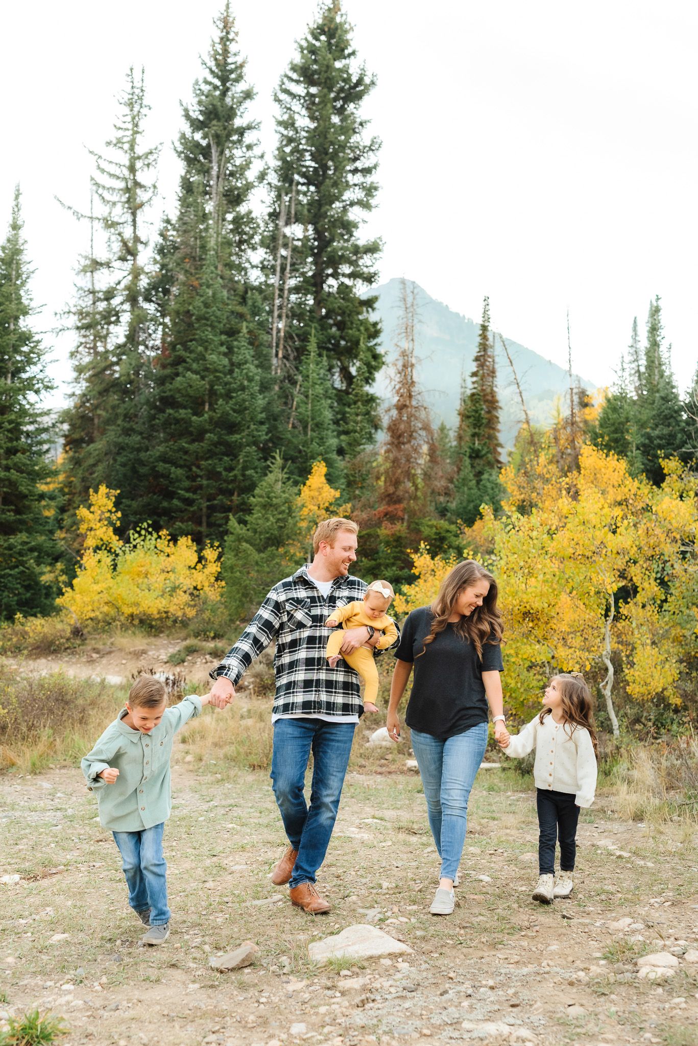 Mother and child sharing tender moments in a mountain setting with fall colors.