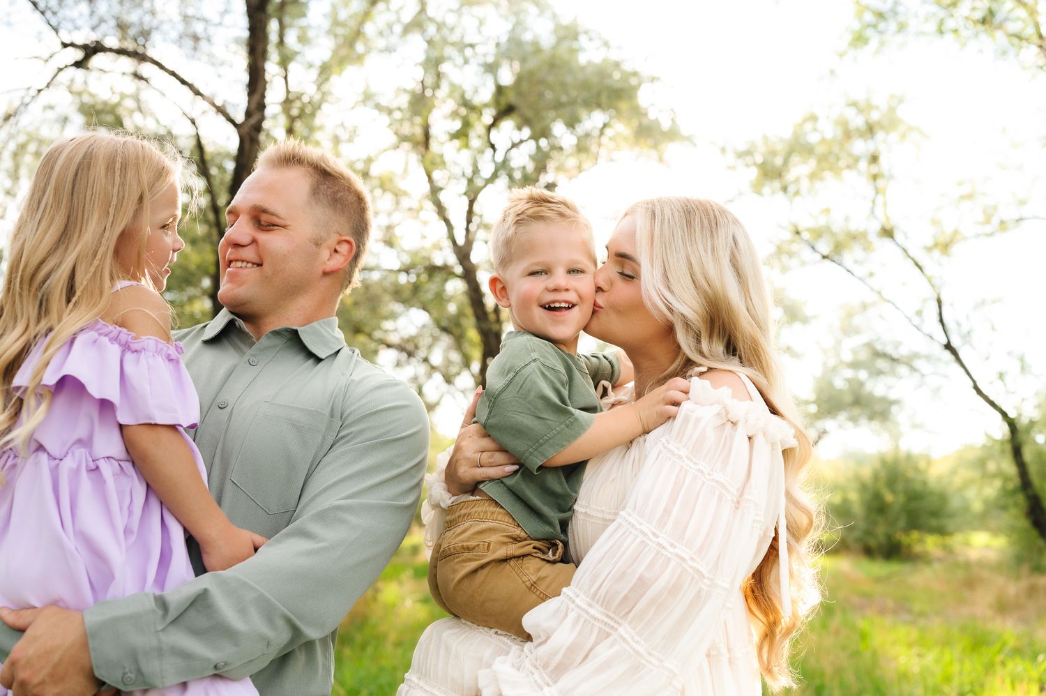 Candid family moments captured in a sun-drenched spring field.