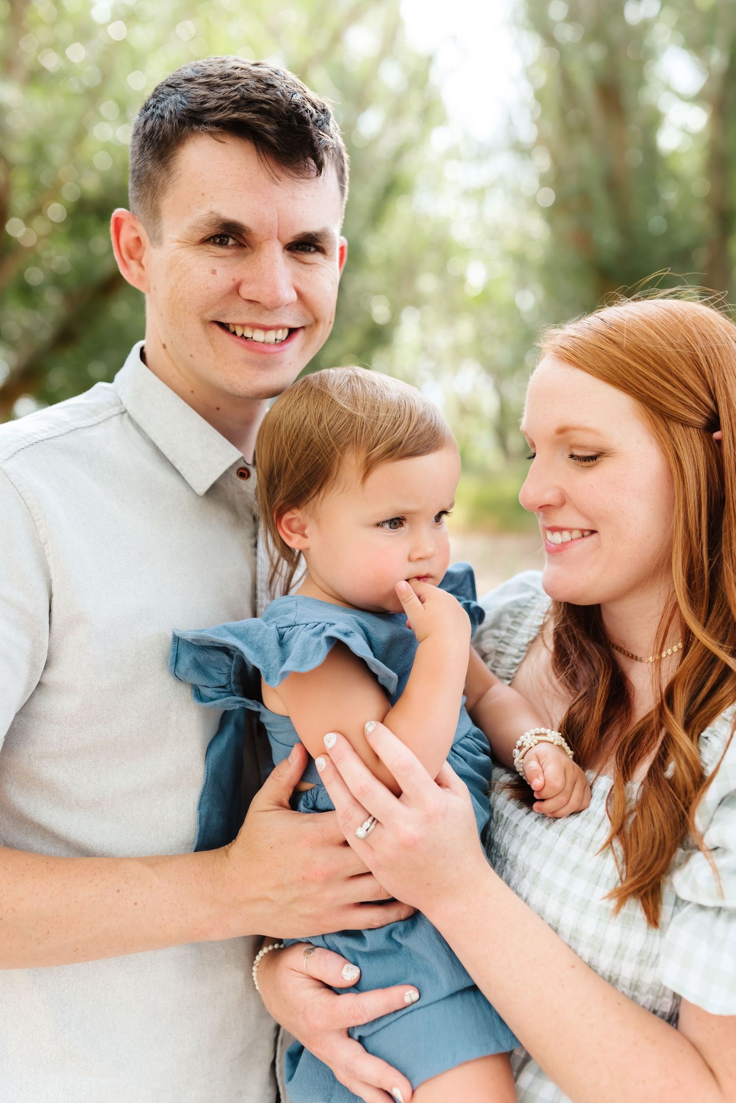 Sweet family moment captured outdoors with natural lighting and gentle expressions.
