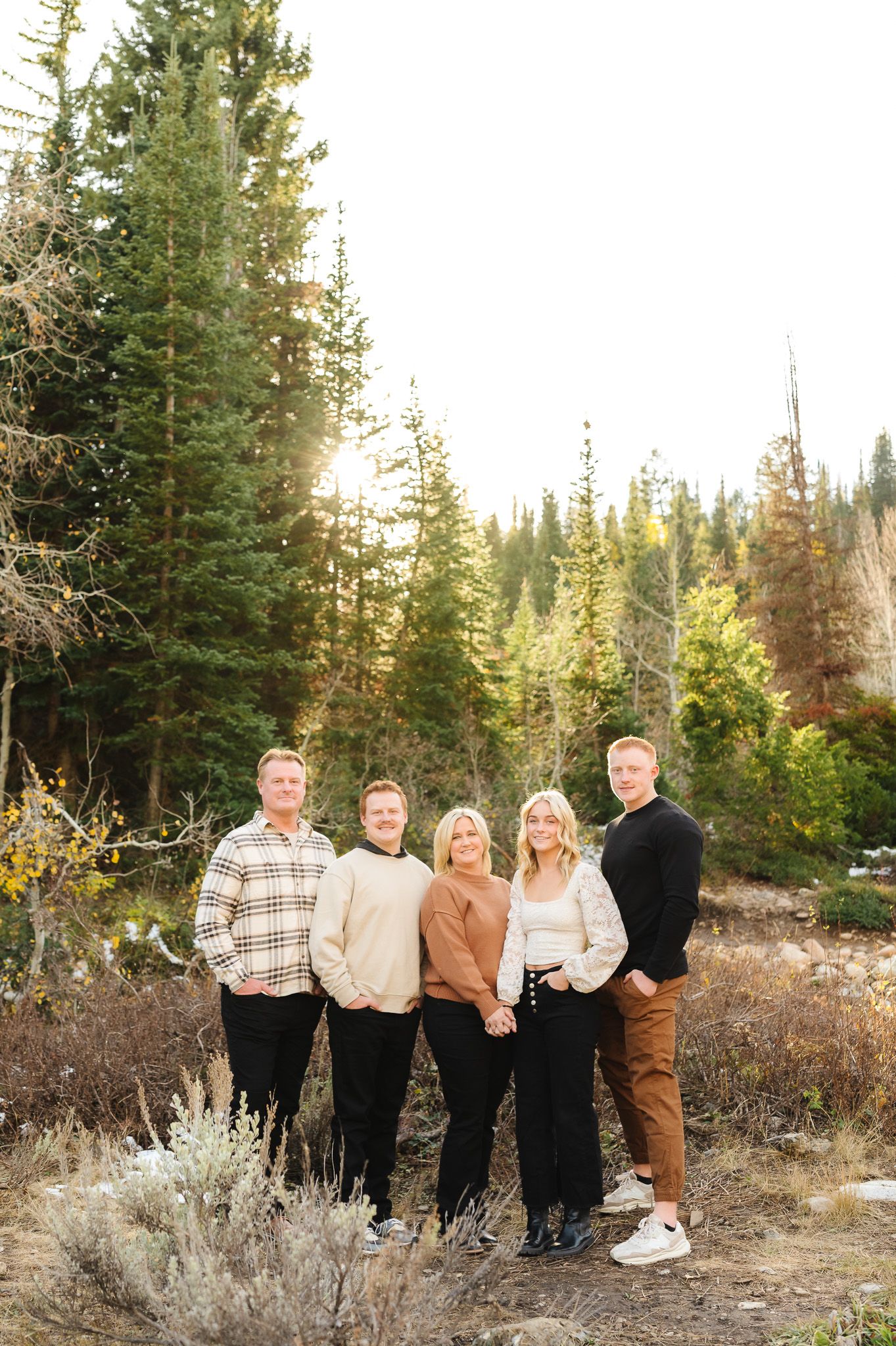 Group photo in casual attire against a backdrop of pine trees and mountain scenery.