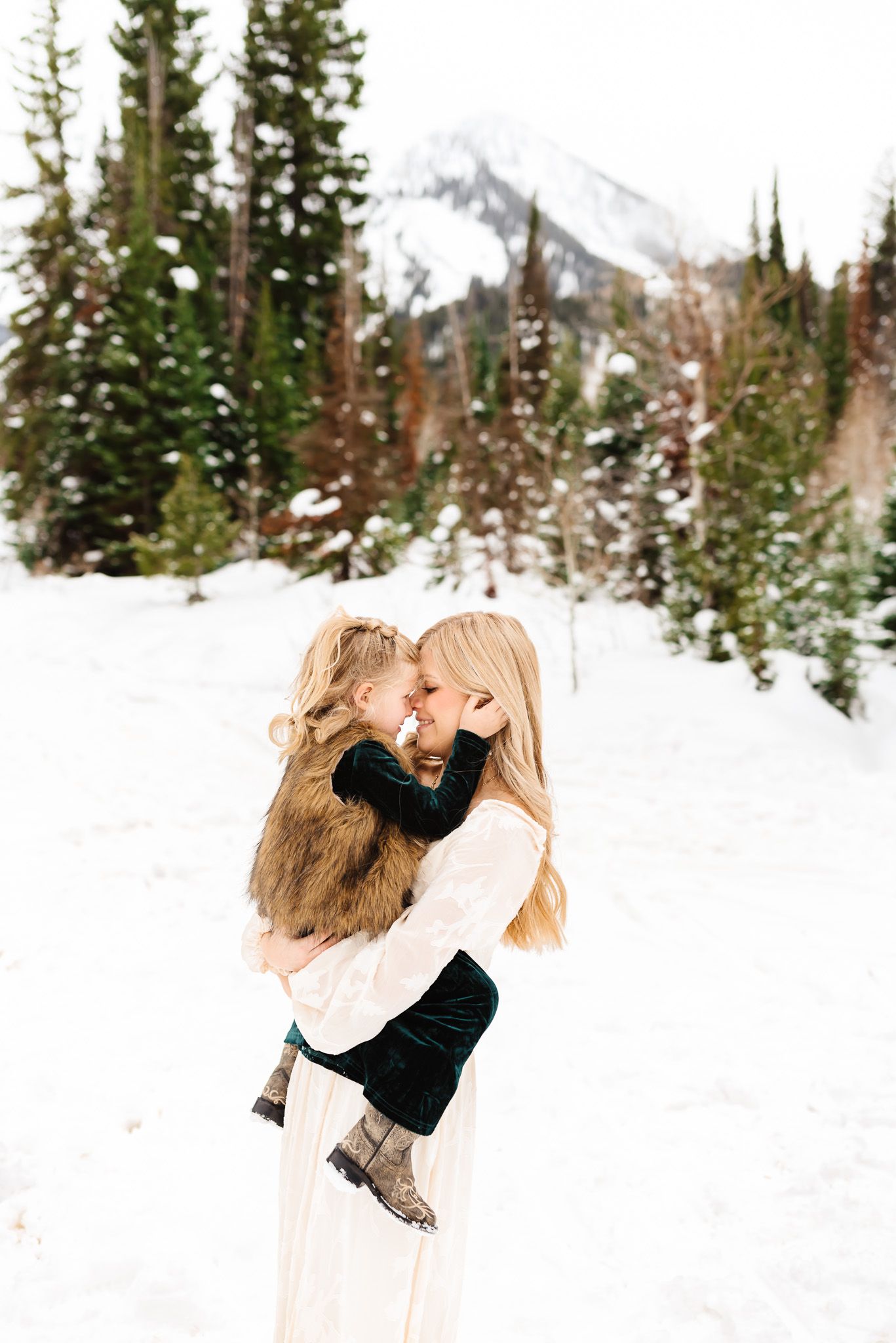 Playful winter engagement photos showing couple's dynamic movements in the snow.