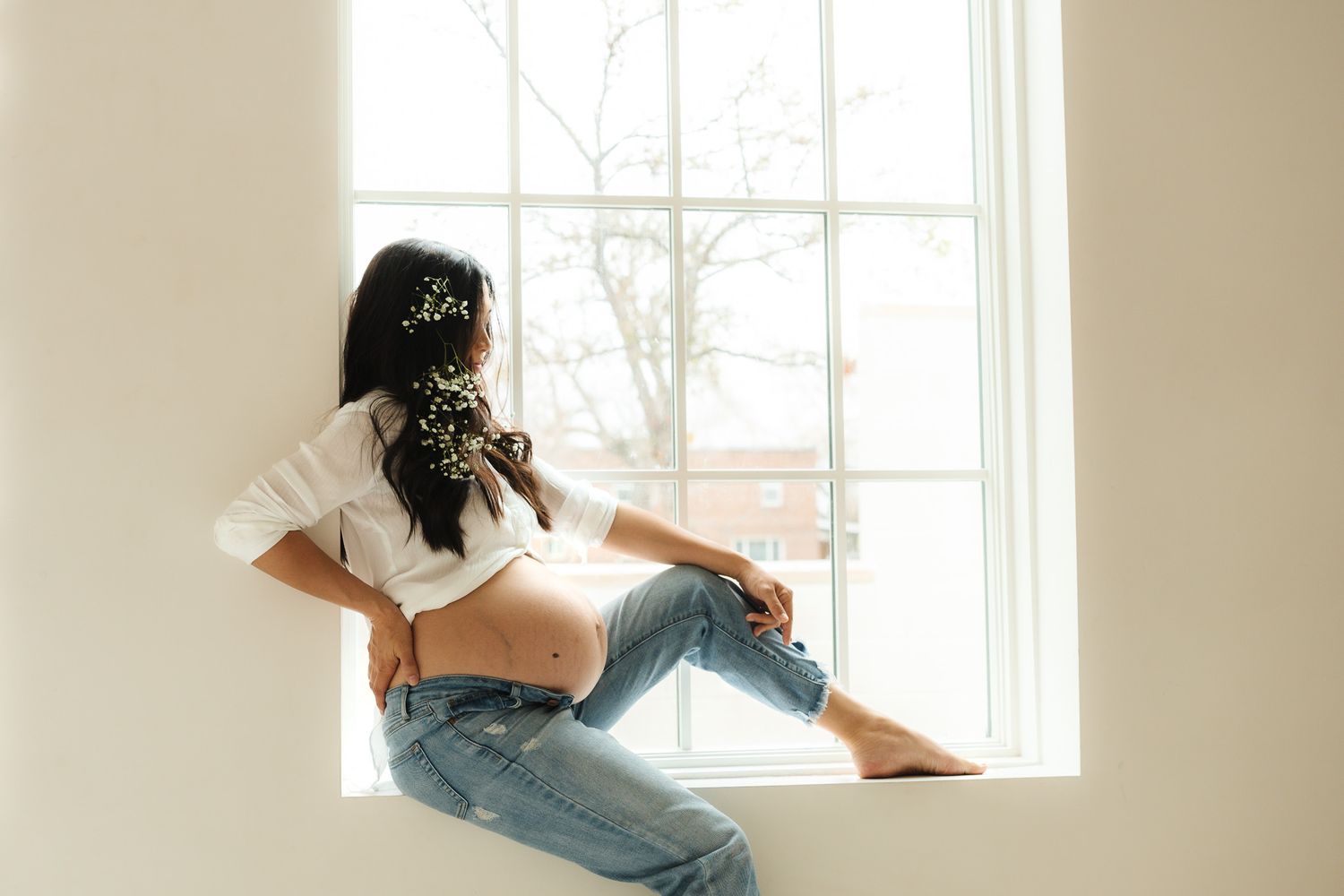 Casual lifestyle portrait by bright window with relaxed natural lighting.