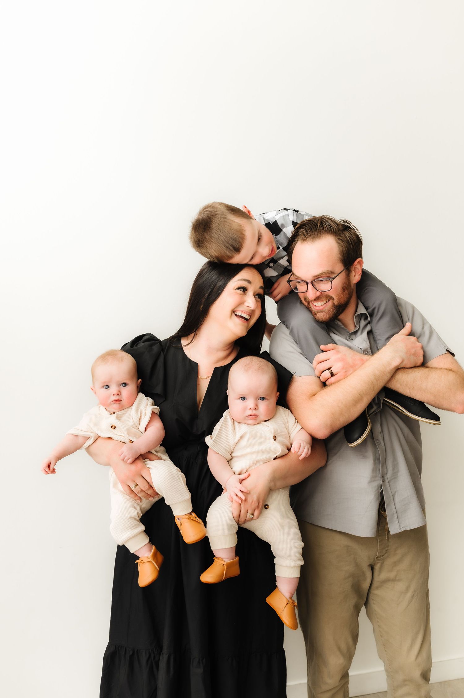 Candid family moment captured against white studio background.