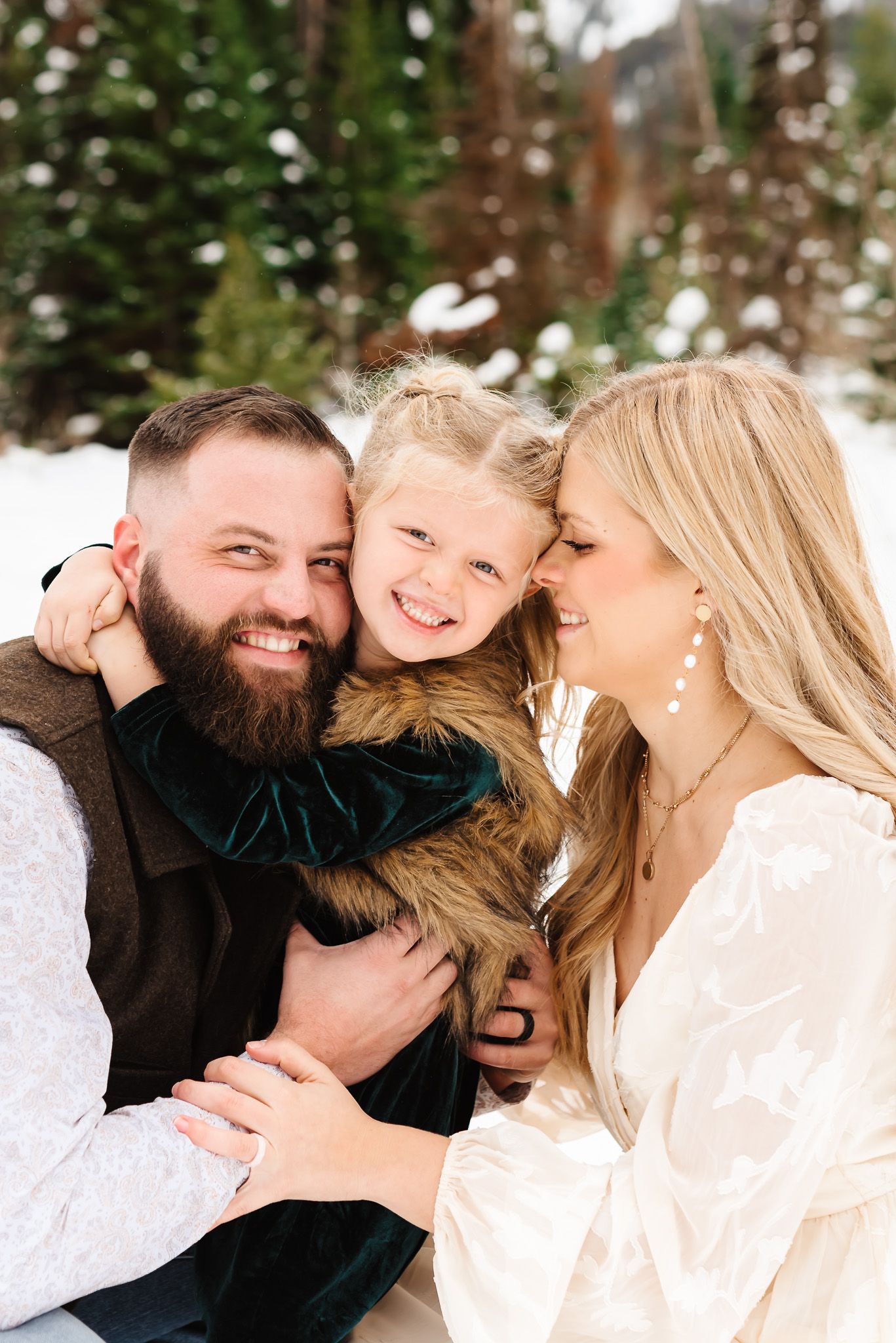 Candid family moments captured in a series of loving interactions against a snowy mountain backdrop during Jordan Pines winter family pics