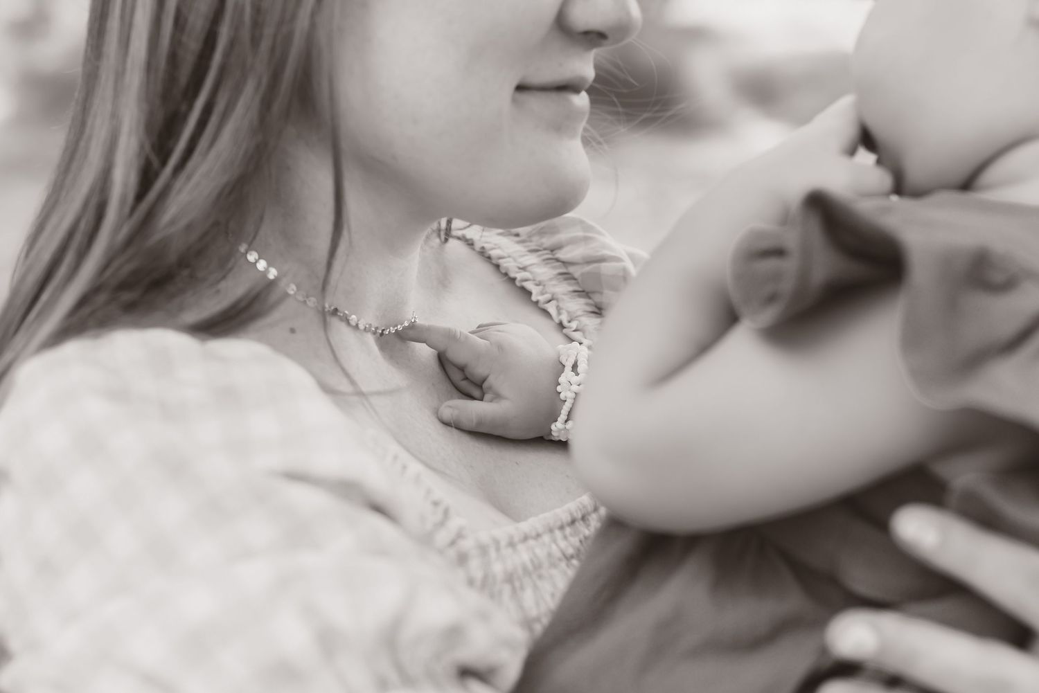 Black and white close-up portrait showing gentle family interaction.
