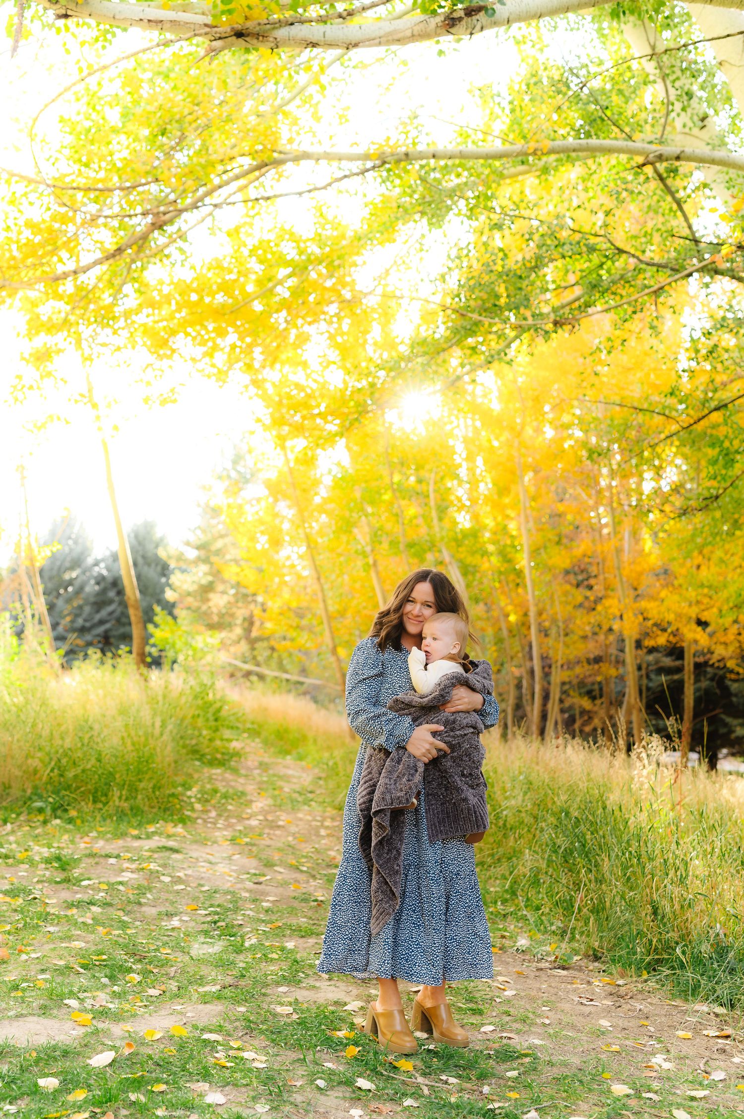 Dancing and twirling moments captured in a golden autumn setting with fallen leaves.