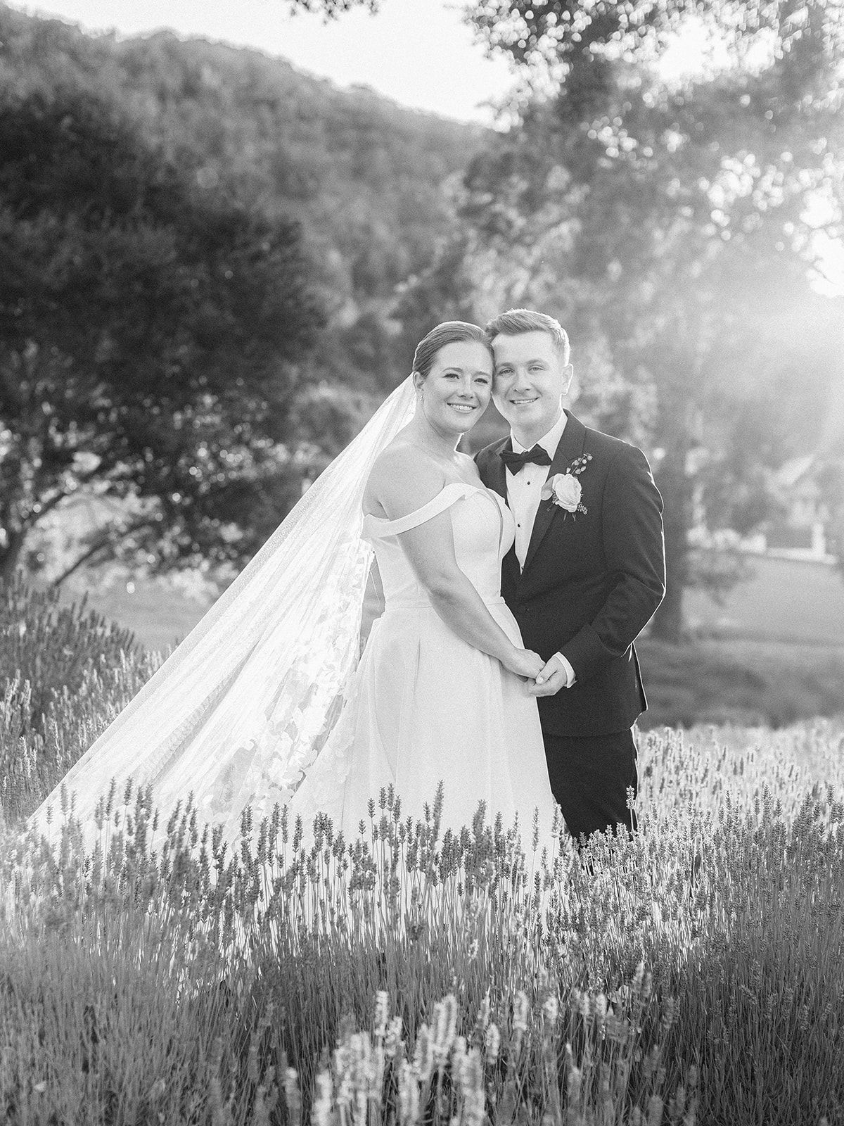 A romantic black and white wedding photo series showing a couple embracing in a blooming lavender field at sunset.