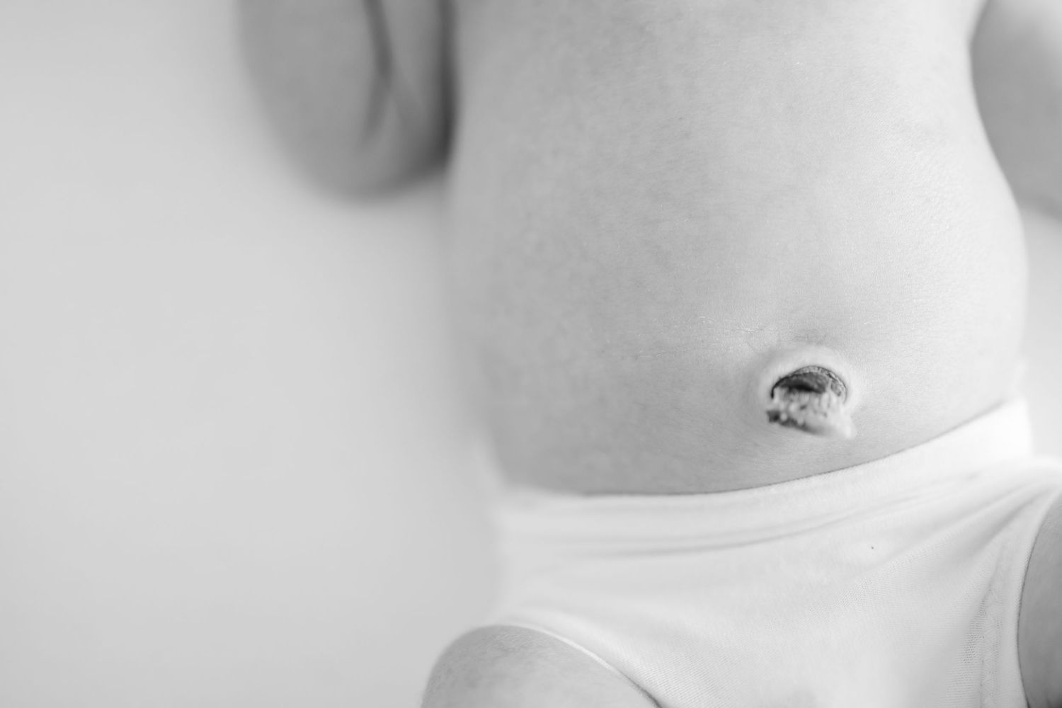 Close-up black and white photo of a newborn belly with umbilical cord stump by Columbus, GA newborn photographer.