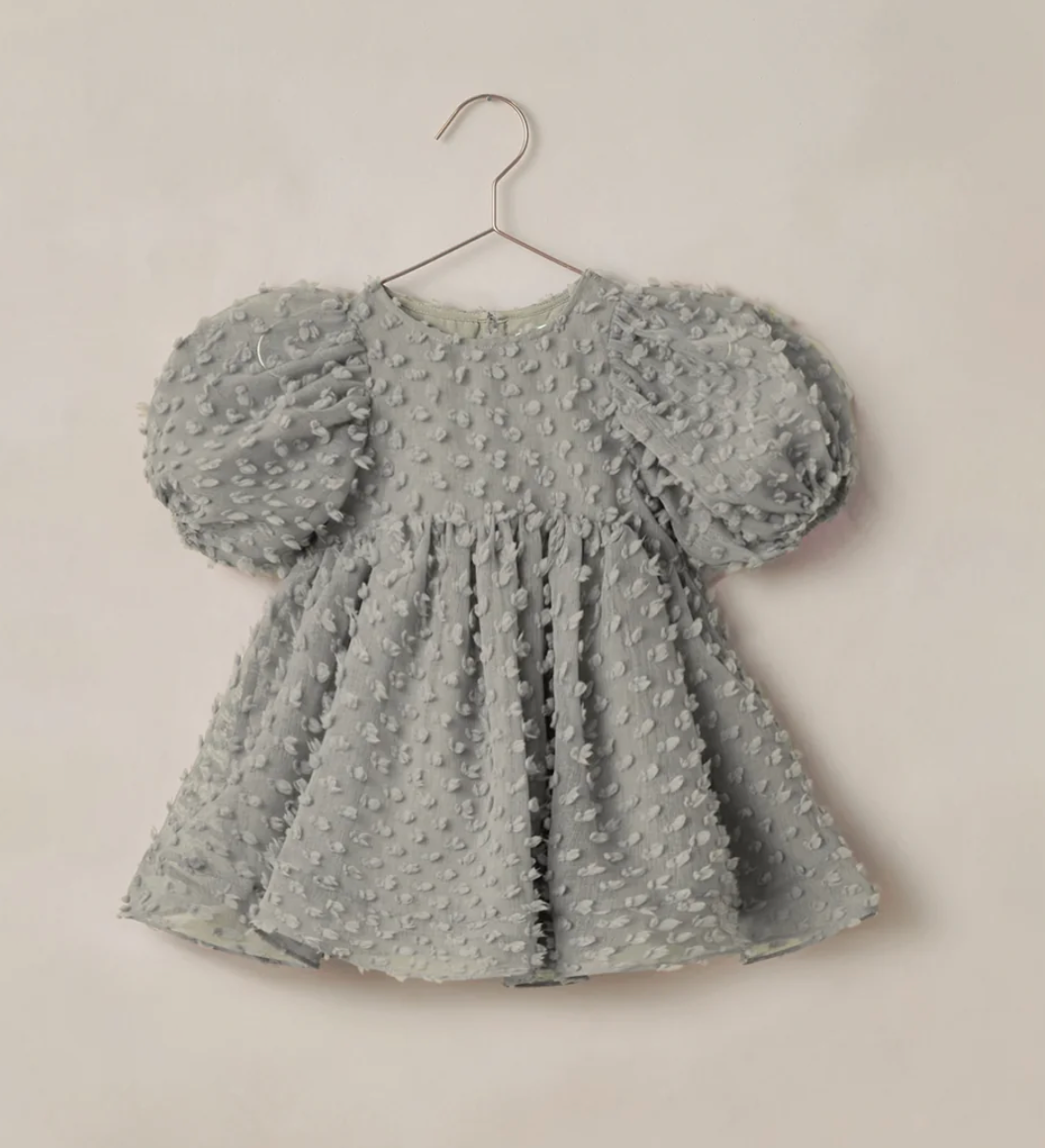 A sage green textured bubble dot dress with puff sleeves on a hanger, perfect for toddlers.