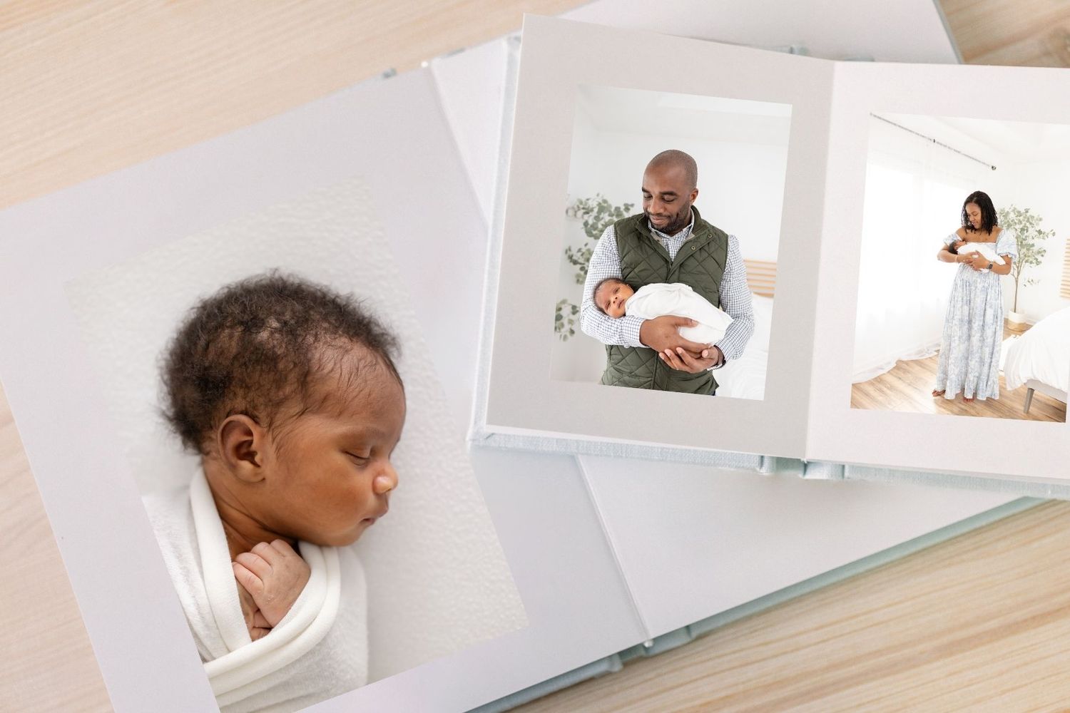 Open photo book displaying newborn baby portrait alongside father holding infant and mother posing in bright nursery.
