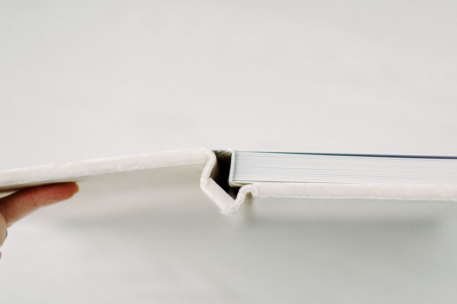Close-up of a white tablet case showing the side profile with a secure snap closure on a light background.