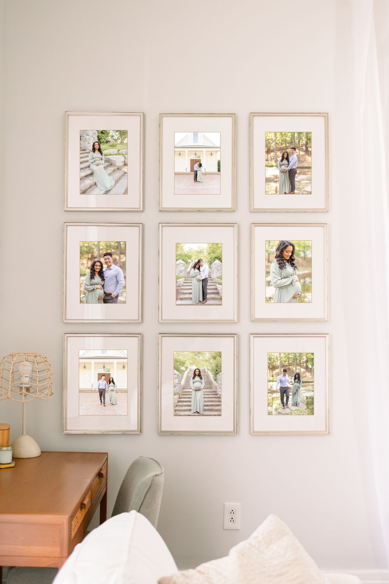 Nine framed couple and family portrait photos arranged in a 3x3 grid gallery wall above a wooden desk in a bright room.