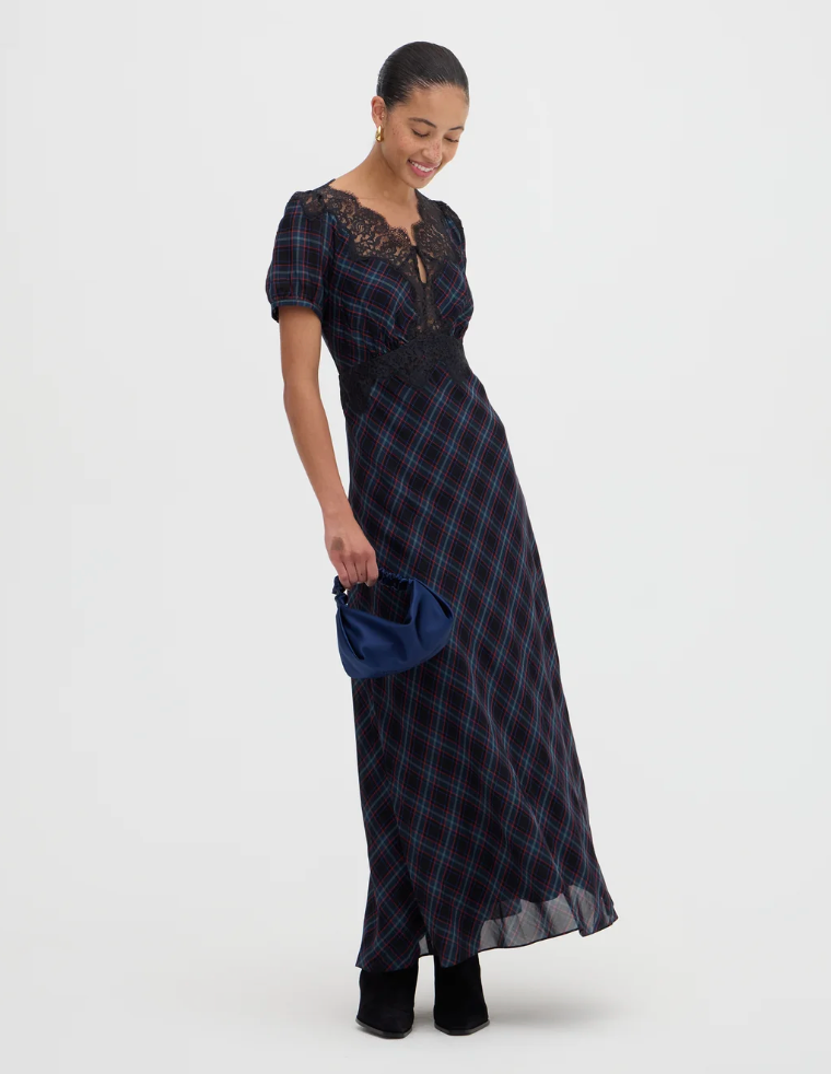 Navy plaid maxi dress with lace neckline, puff sleeves, and black ankle boots, styled with a blue clutch bag.