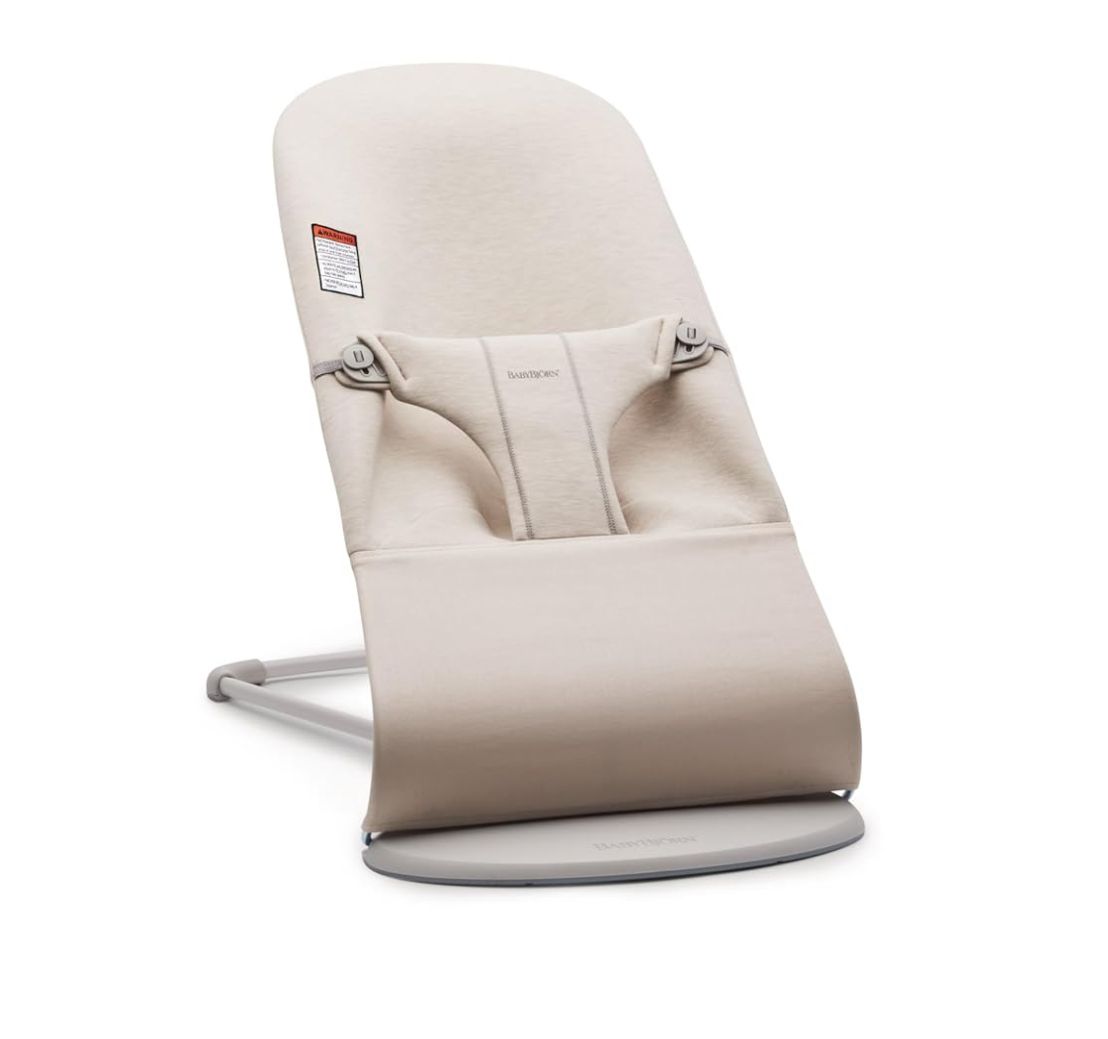 Modern beige baby bouncer seat with ergonomic design and metal frame for infant comfort and support.