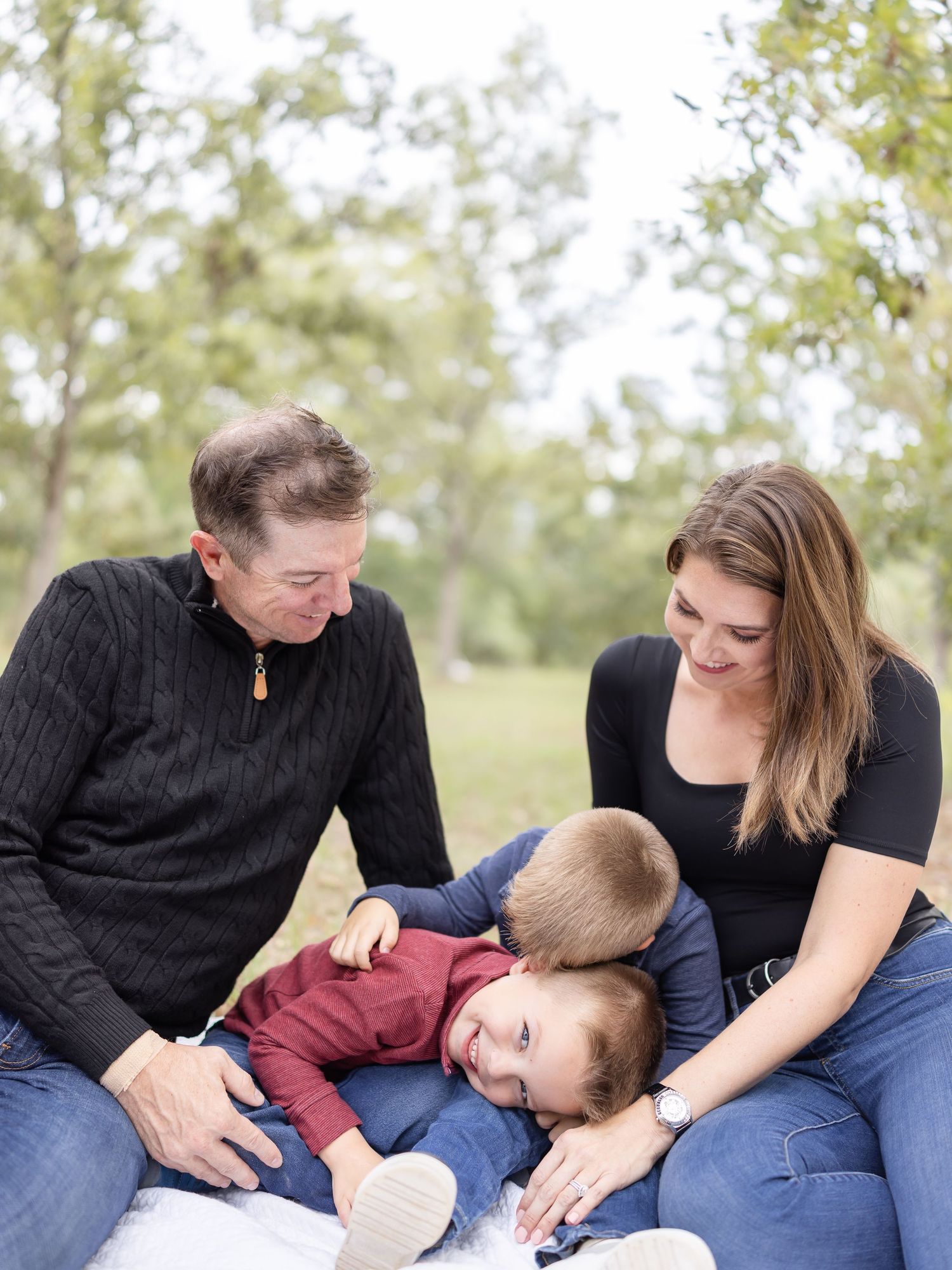 A playful family moment captured outdoors with casual attire and natural lighting on their family property by Columbus, GA photographer.