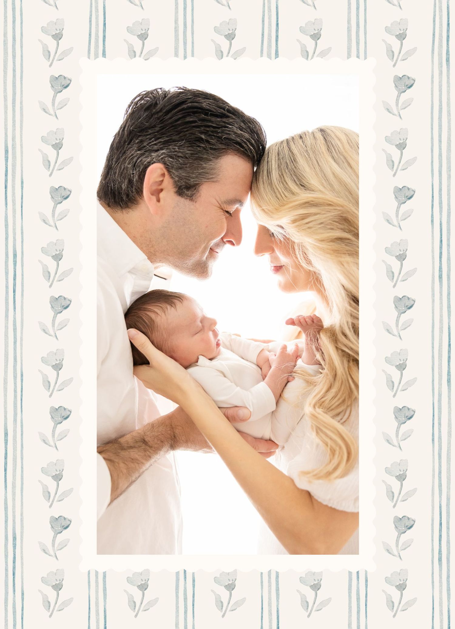 New parents tenderly holding their newborn baby, dressed in white, surrounded by a delicate floral border design.