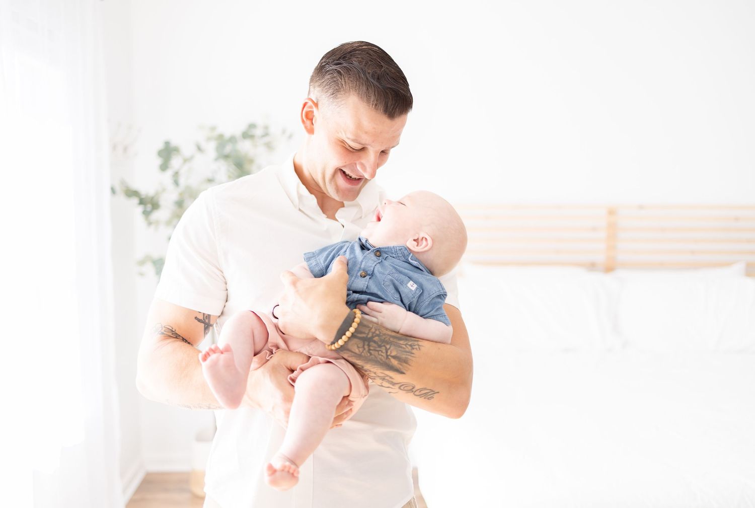 Parent and baby share a joyful moment together while bonding in a bright, airy room.
