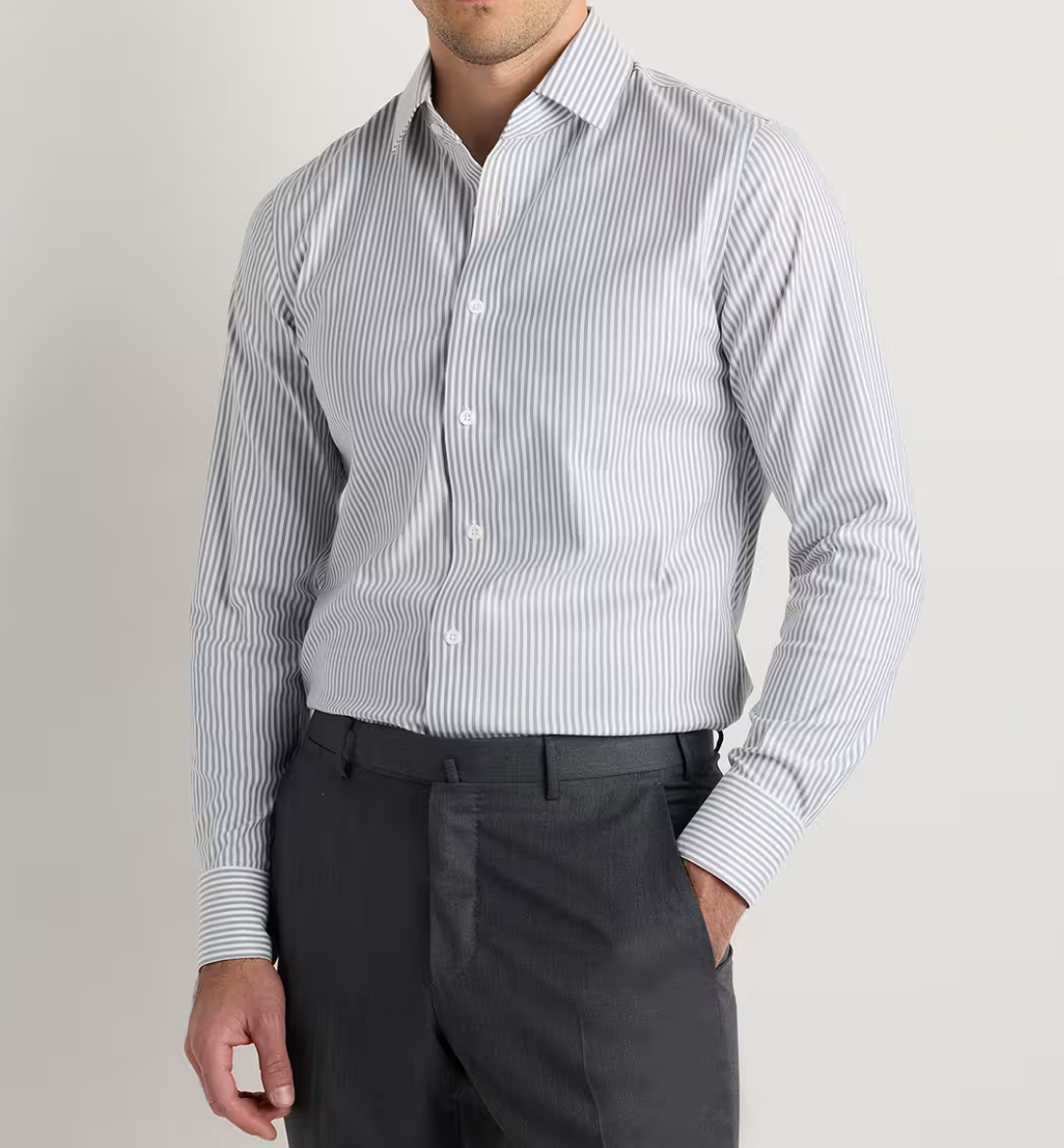 Man wearing a white and grey striped long sleeve dress shirt with dark grey trousers.