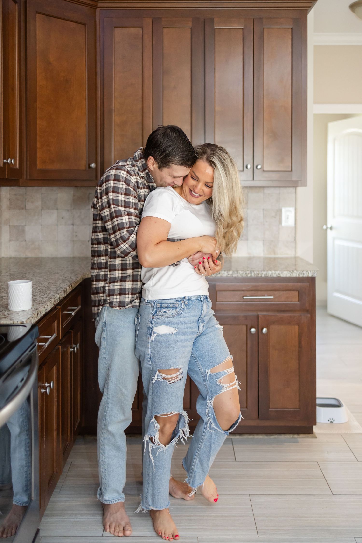 A husband and wife embracing in their kitchen during their Columbus, GA couples photography session.