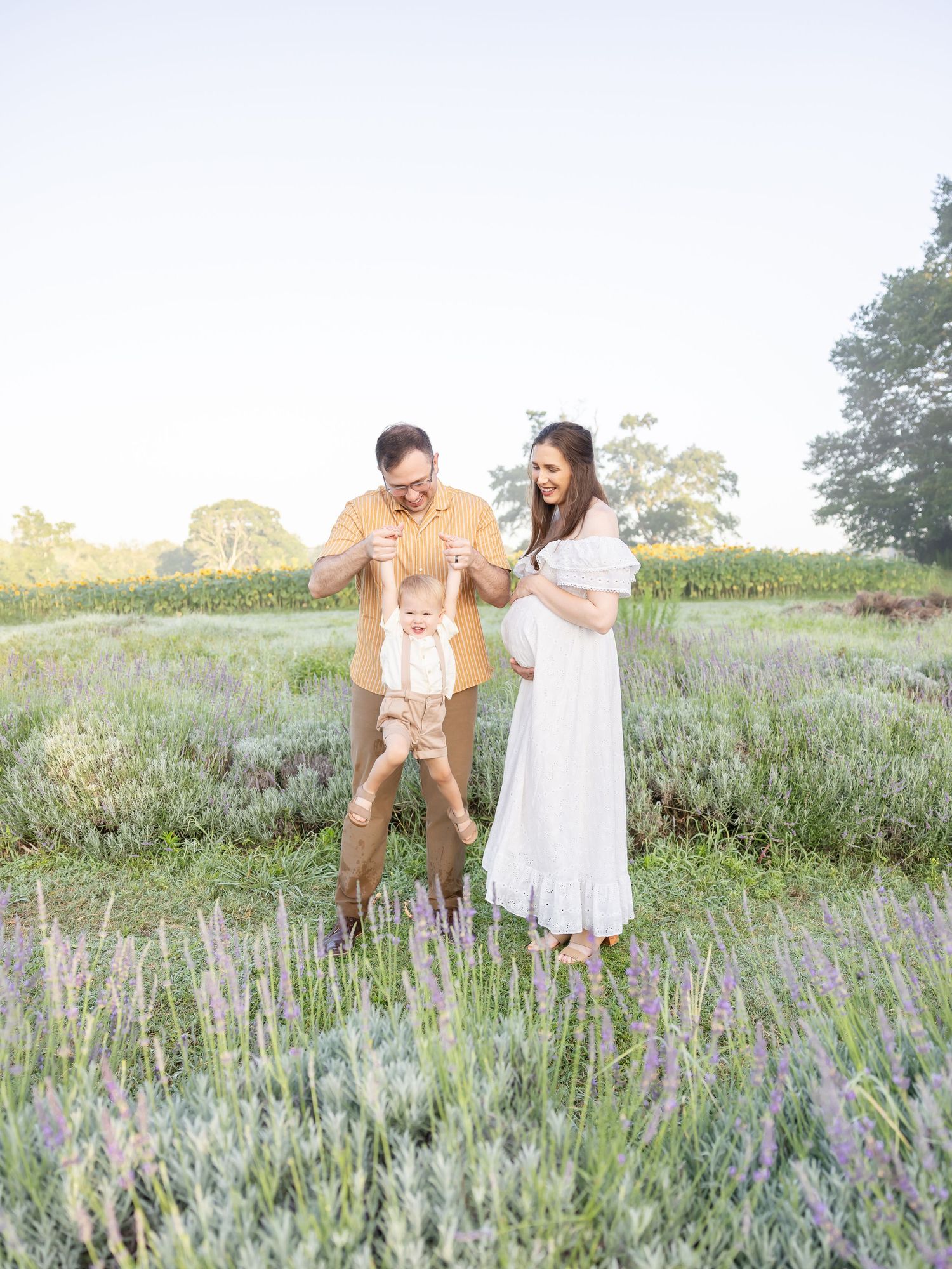 Couple shares playful moments together in a blooming lavender field during sunset.