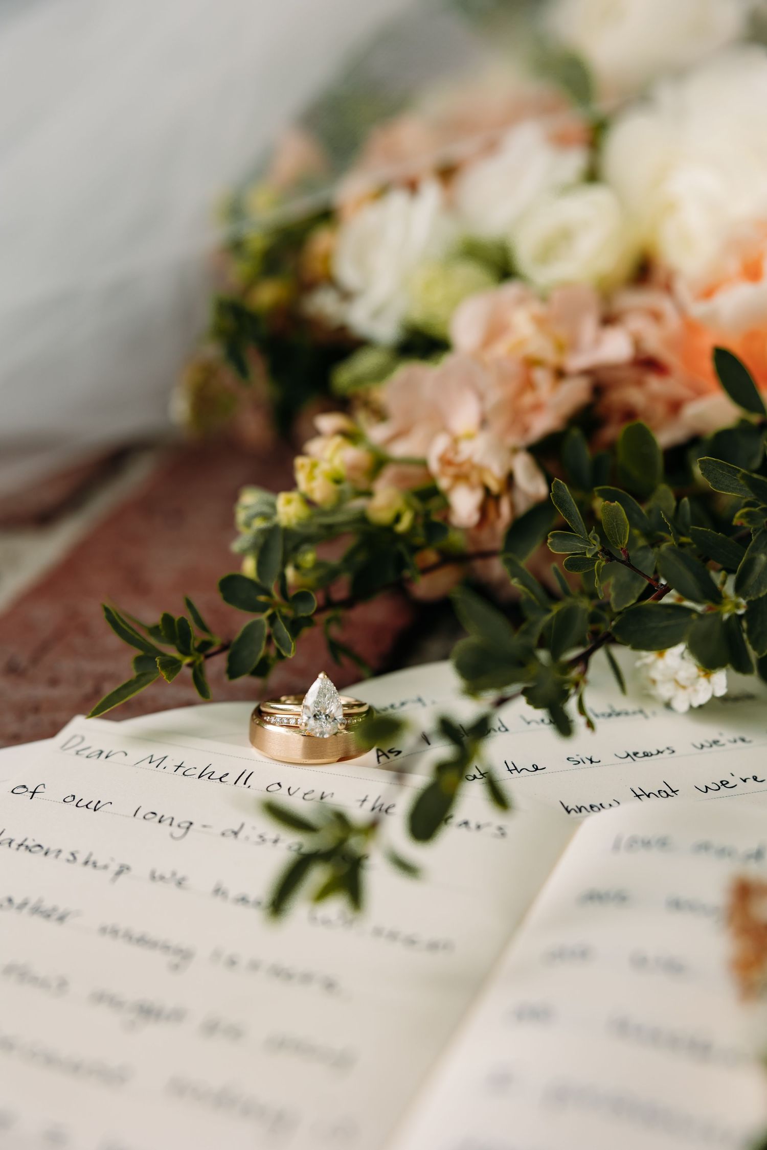 Wedding rings and vows with delicate flowers and greenery.