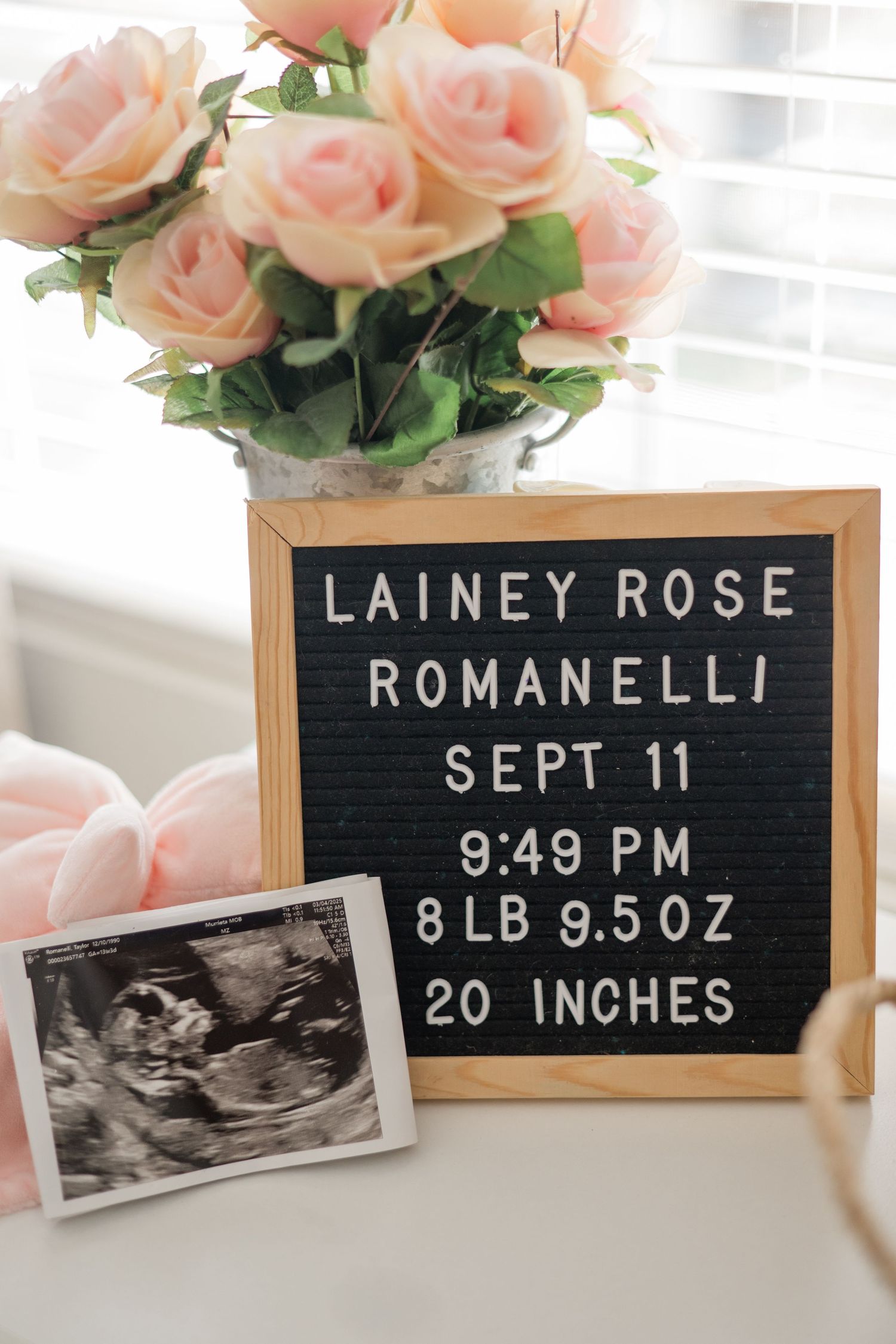 Birth announcement letter board for Lainey Rose Romanelli, born Sept 11 at 9:49 PM, 8lb 9.5oz, with ultrasound photo and pink roses.
