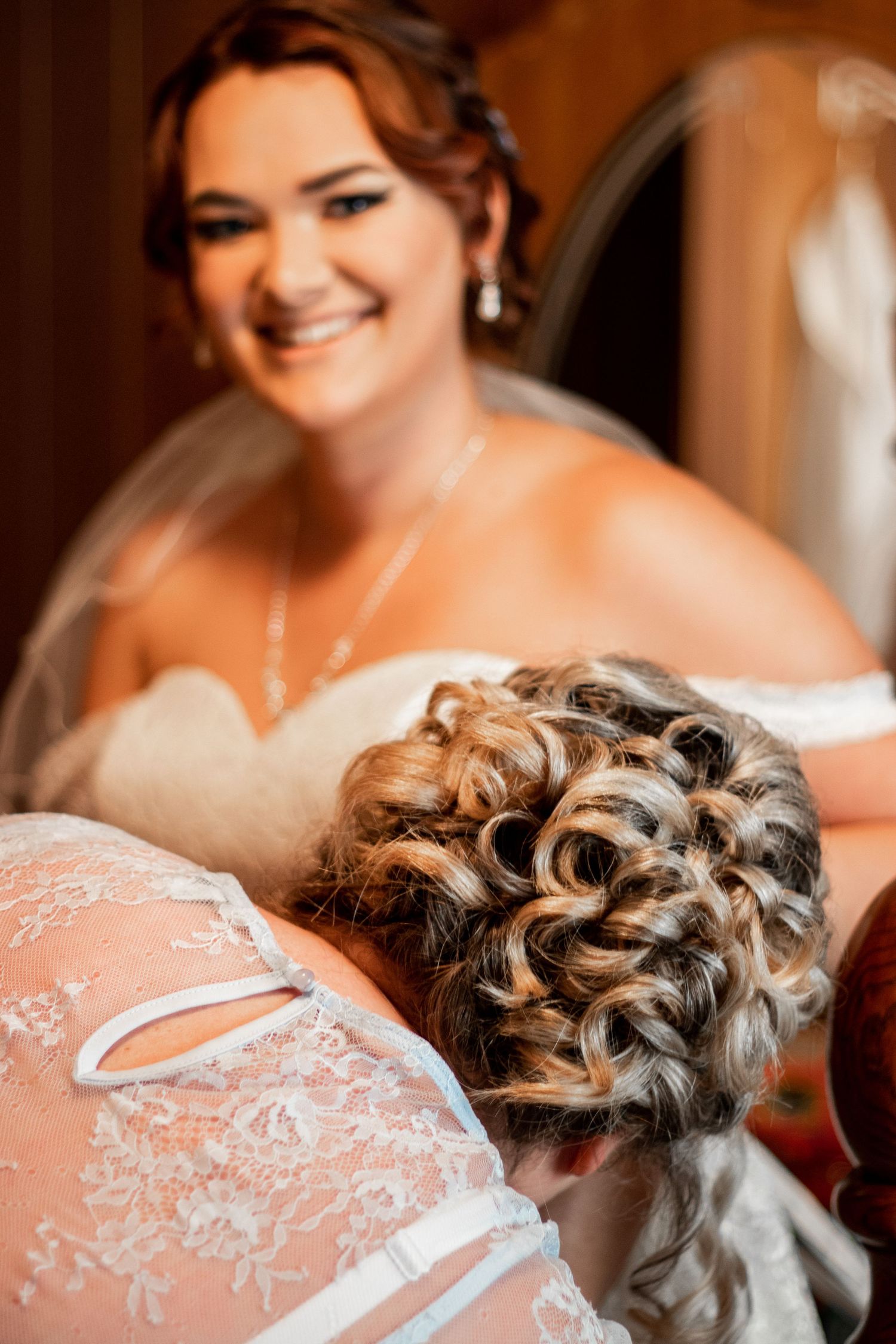 Close-up details of intricate lace wedding dress and elegant bridal hairstyle.