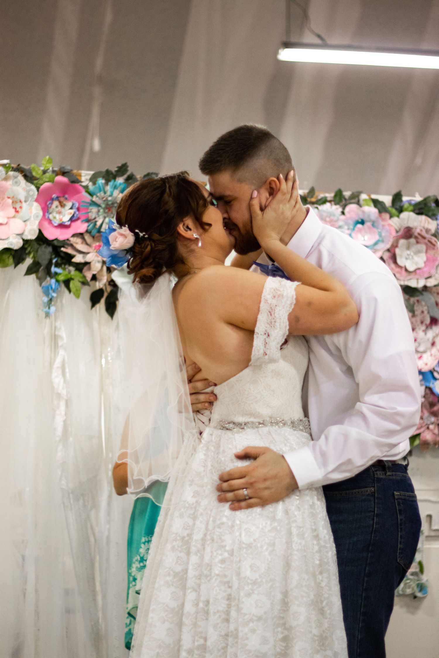 Wedding couple embraces in a romantic sequence of photos with floral decorations in the background.