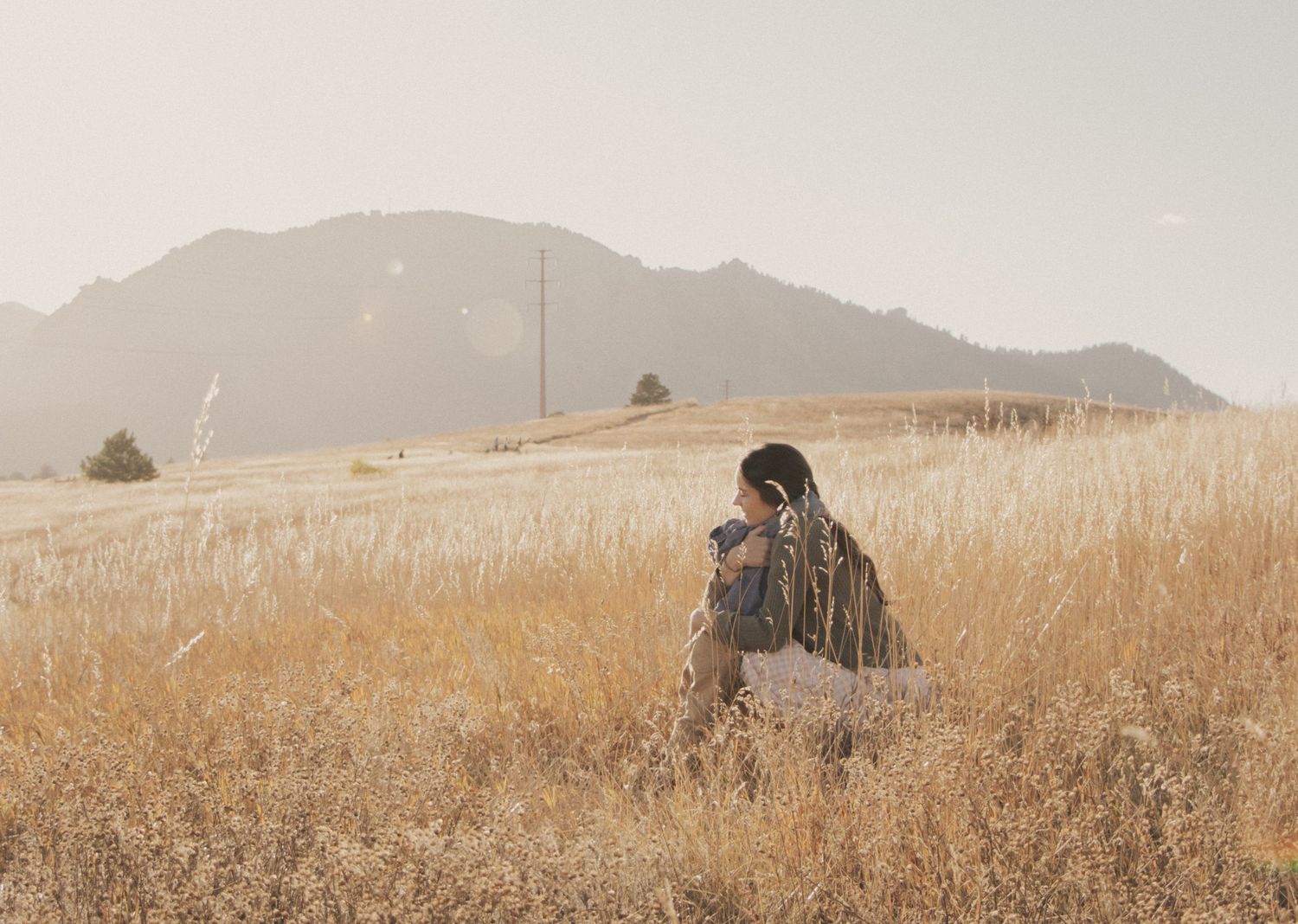 Photographer captures candid moment in golden wheat field with mountains.
