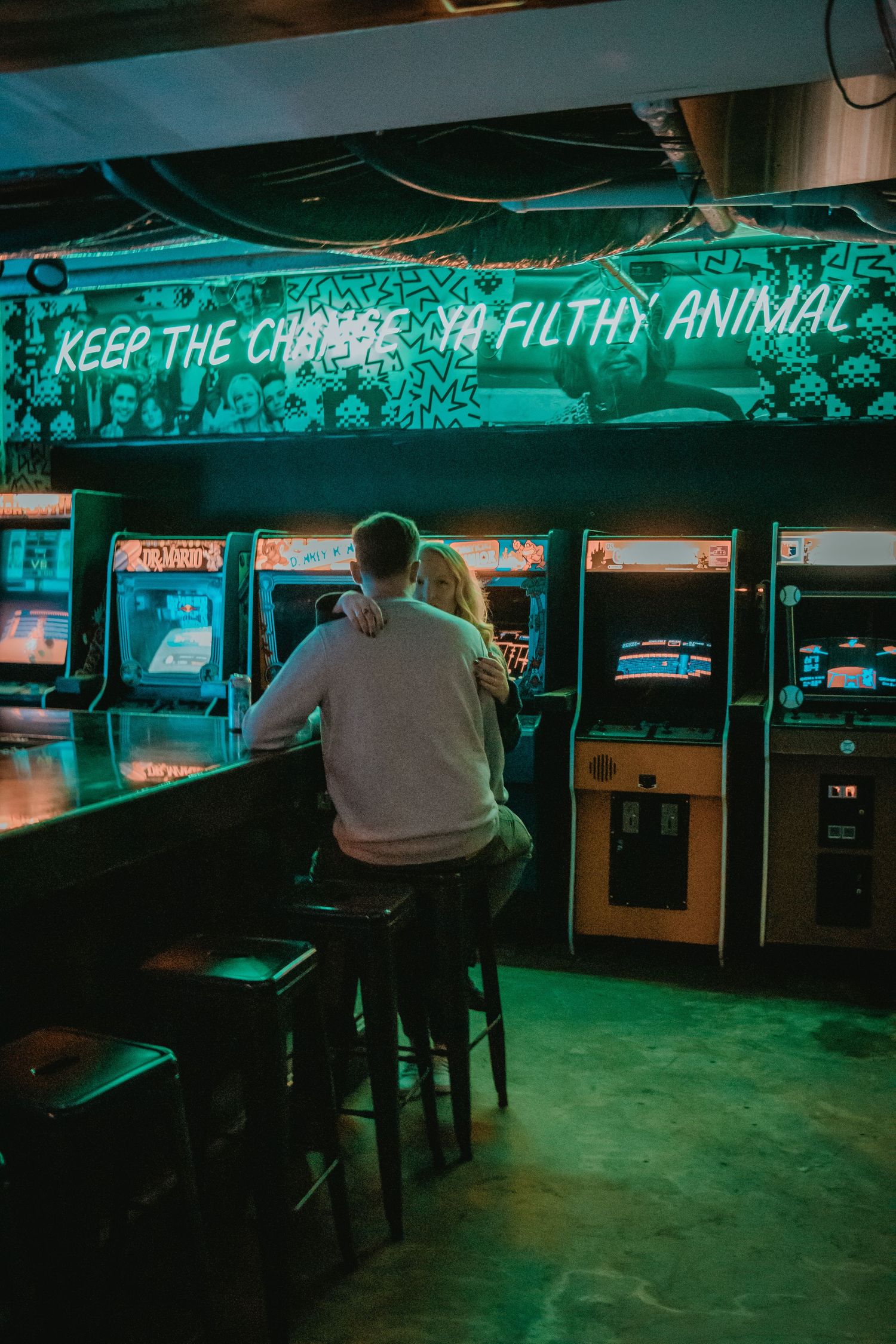 A retro arcade interior with neon signs and vintage gaming cabinets.