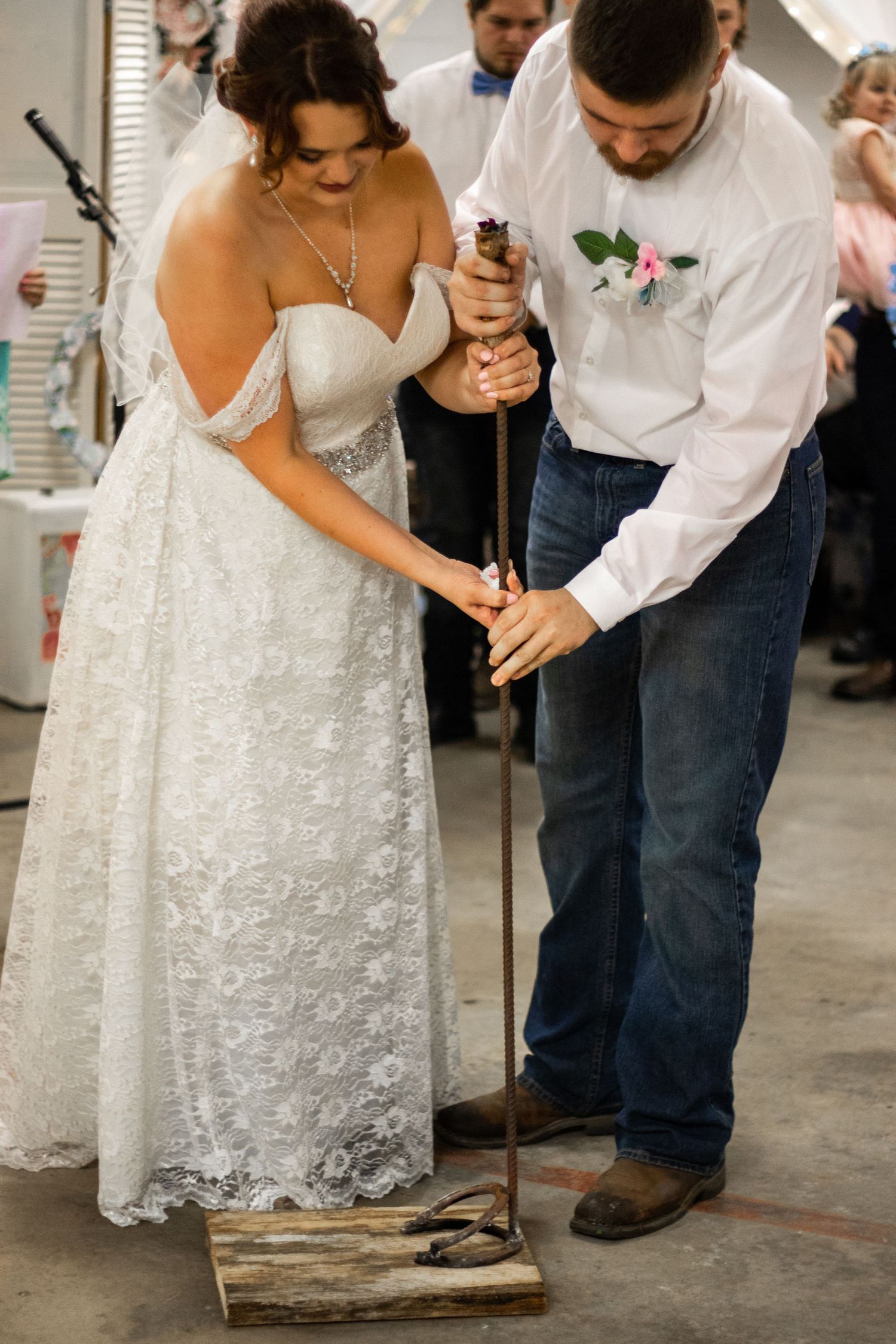 Couple shares a sweet moment while signing their marriage license on a rustic wooden box.