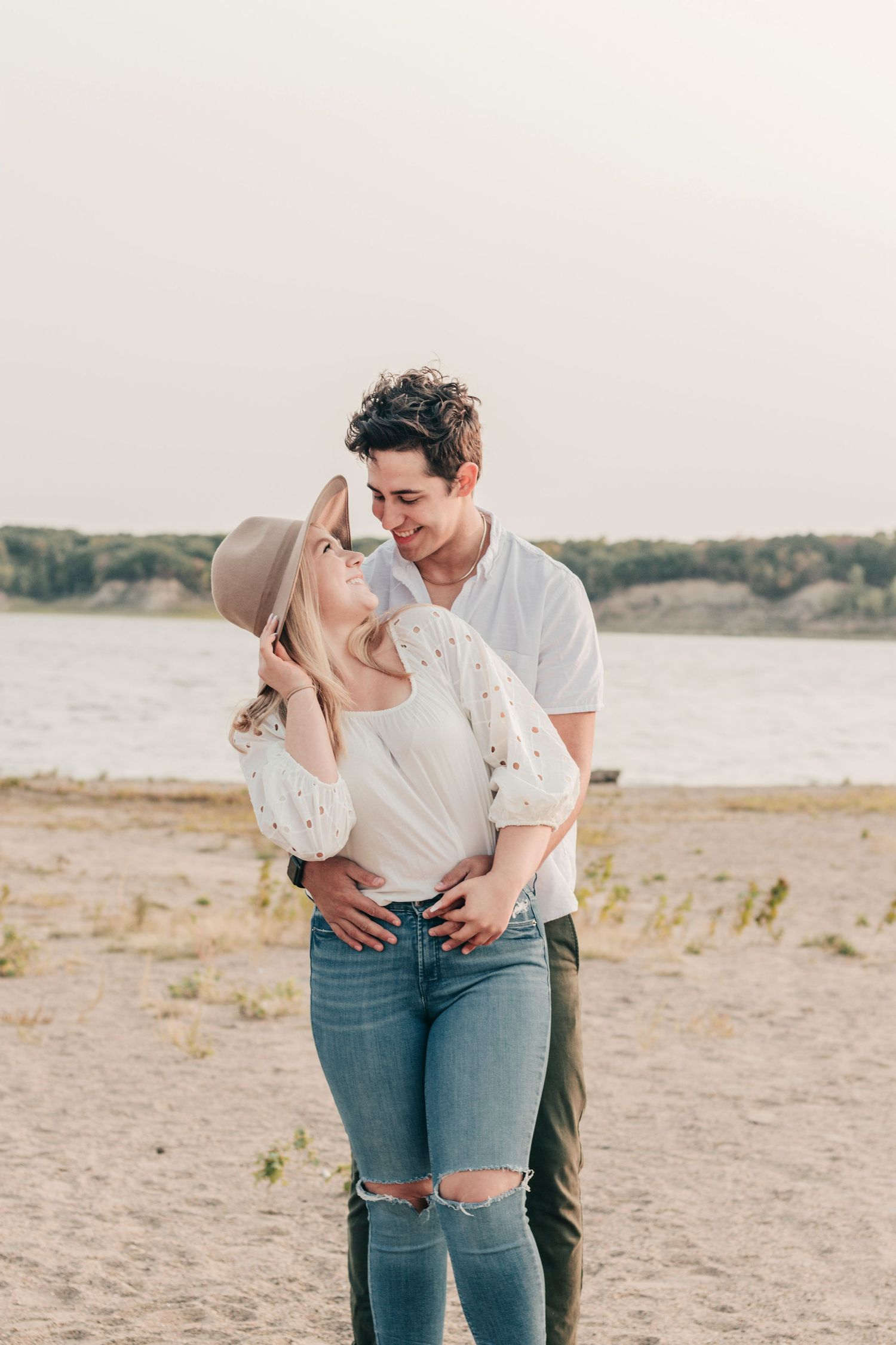 A couple shares an intimate moment while standing together at the beach.