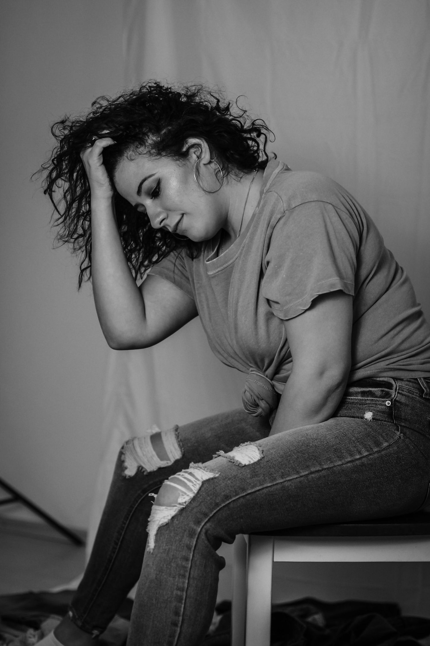 Dramatic black and white portrait capturing contemplative mood in casual attire.
