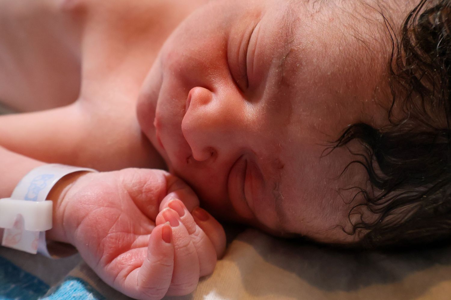 Close-up profile view of newborn baby resting peacefully.