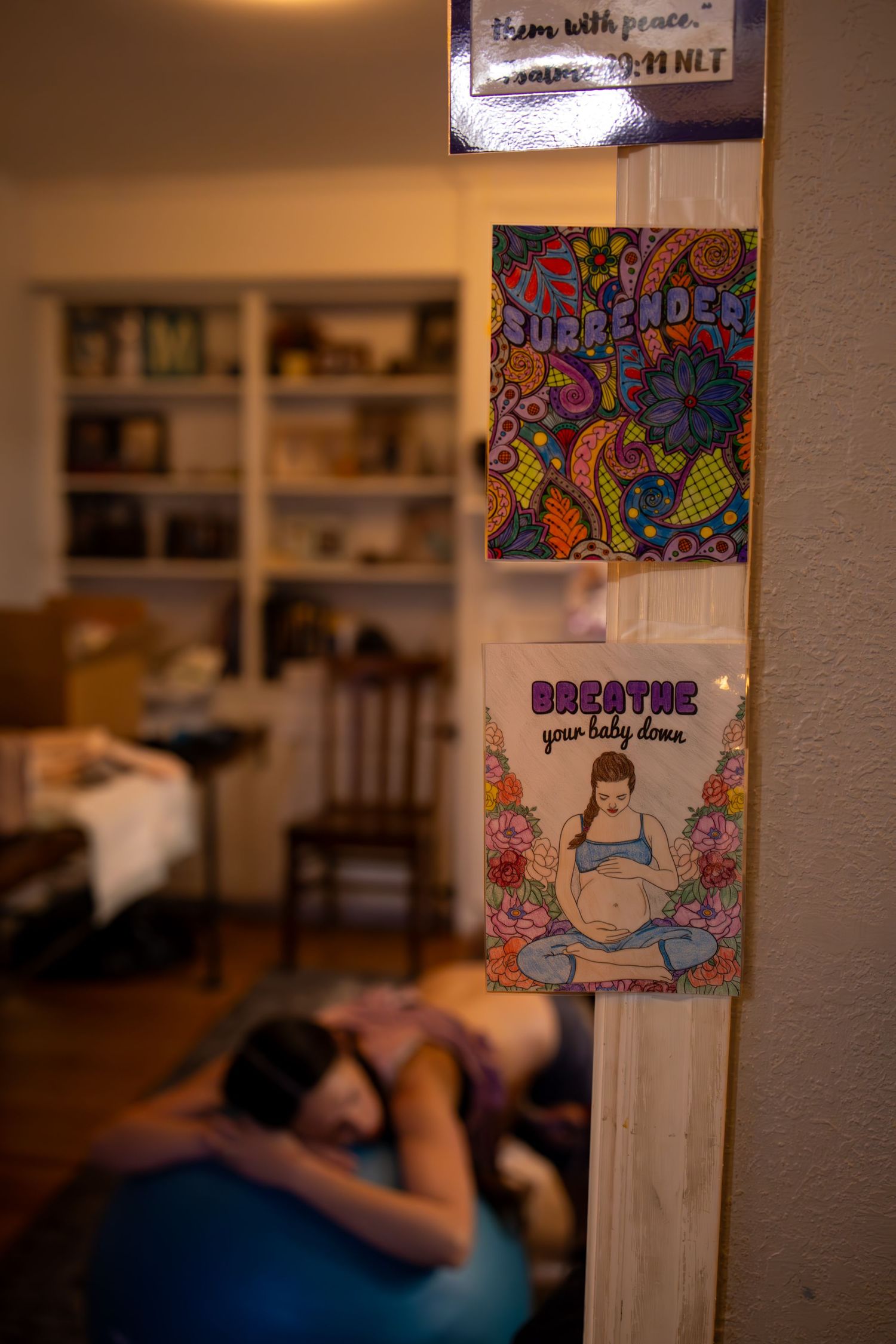 Colorful artwork and decorative signs adorning a wall. Wichita birth photographer documenting a home birth