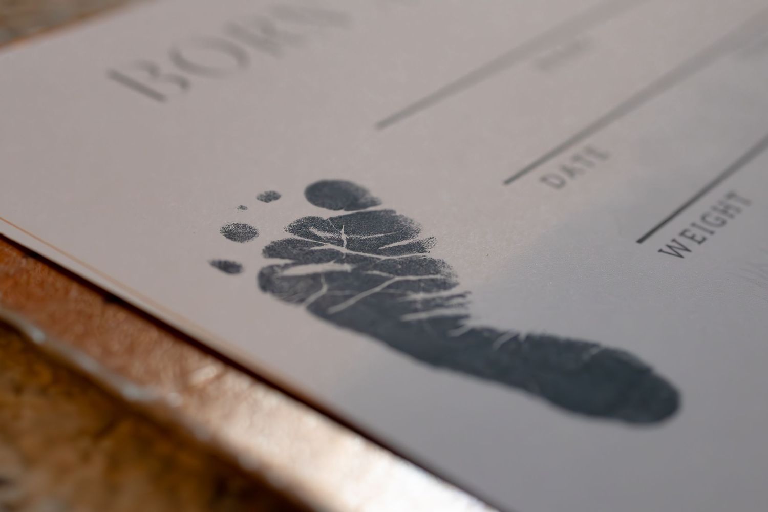 Baby footprints being stamped onto white paper or documents.